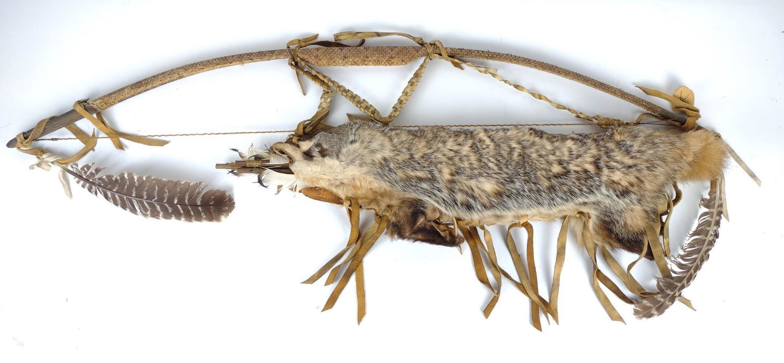 T. Hawk Rattlesnake Skin Bow & Badger Skin Quiver: Signed T. Hawk. Three arrows in quiver. Bow 49" long. quiver 30" long x 9" wide. DP. IMPORTANT: Before bidding, please read the terms and conditions. When you registered for the auction you agreed to