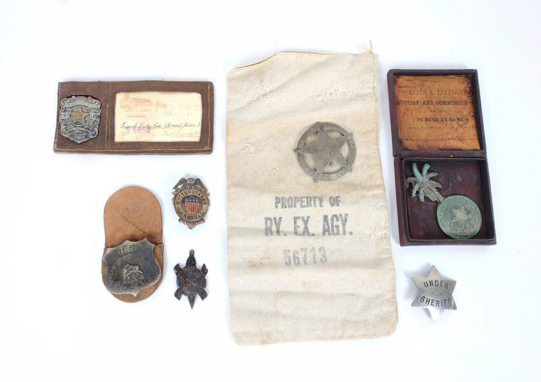 9 Western Style Badges: Late 20th century aged police badges. Includes Under Sheriff, reproduction North West Fur Co. Trade Turtle, multiple US Marshall Badge, American Railway badge with accompany railway stamped bag, U.S. 