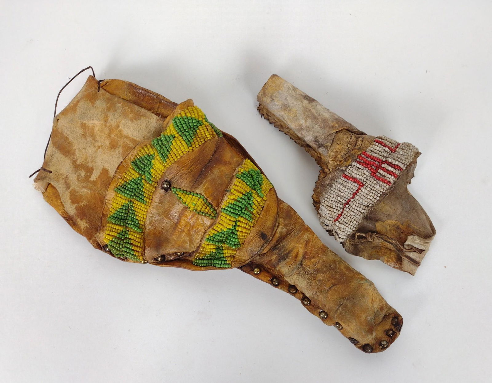 2 Native American Style Beaded Holsters: Late 20th century, aged holsters. Intended to hold Colt Army revolvers. One with lazy stitch decoration in the style of the Cheyenne. Second with green ground beading in the style of Northern Plains I