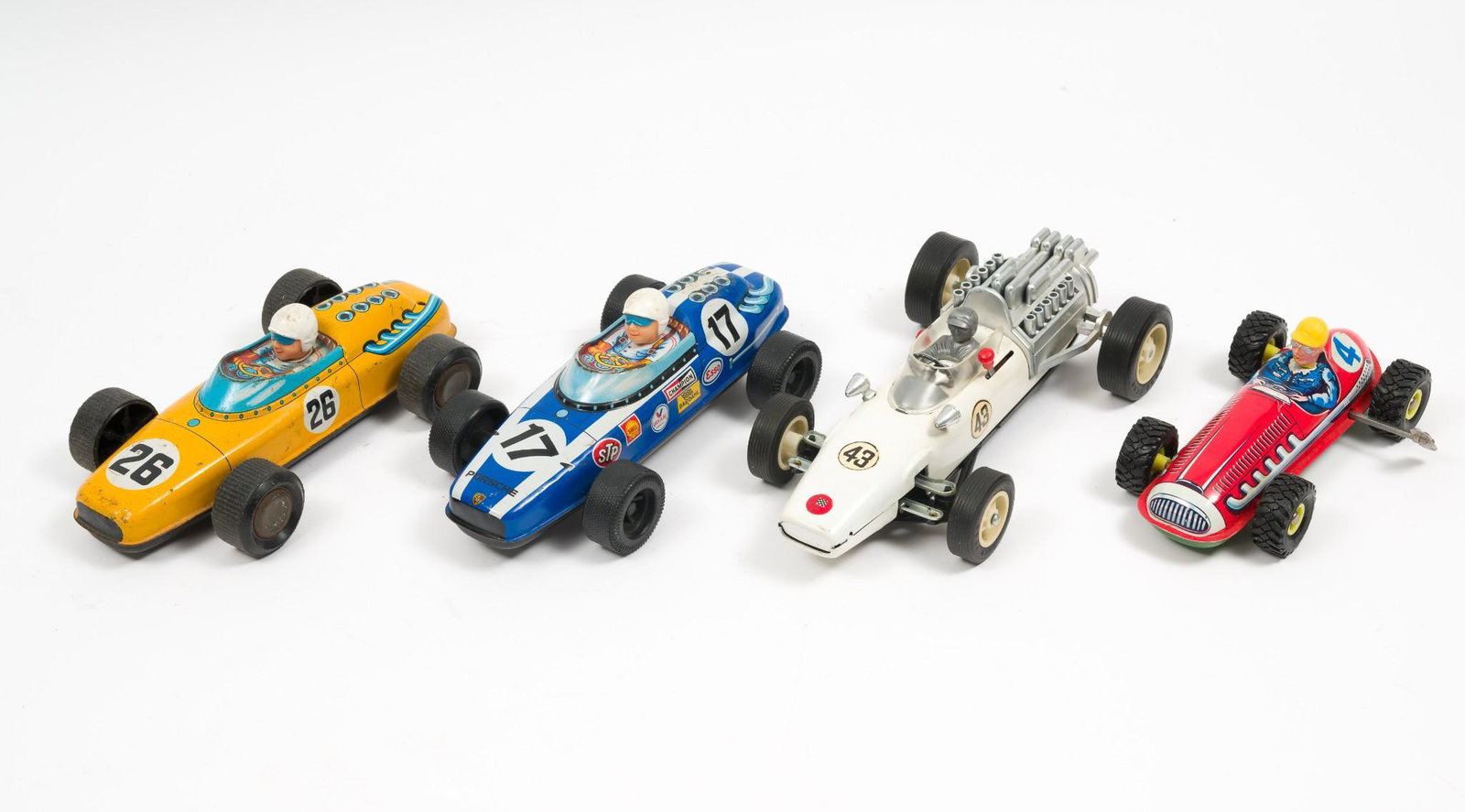 4 Tin Racers Incl Wind-up, Battery, Friction: Includes wind up tin racer #4 marked Made in West Germany; battery operated Bandai, Made in Japan, Indy Racer #43, working, two tin friction racing cars, one marked Porsche, Made in Japan, with advert