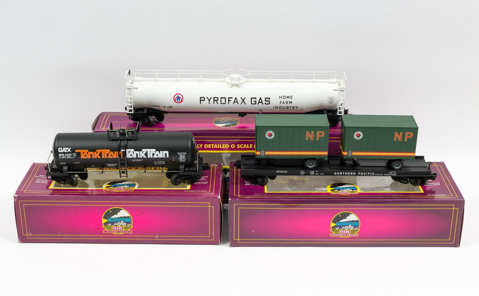 3 MTH Freight Cars with OBs Incl Pyrofax Gas Tank: Includes 96007 Pyrofax Gas 33K Gallon Tank car, 92008 G.A.T.X Tank car, and 98105 Northern Pacific Flat car with 20' trailers. All very lightly run with original boxes. MH. IMPORTANT: Before bidding, 