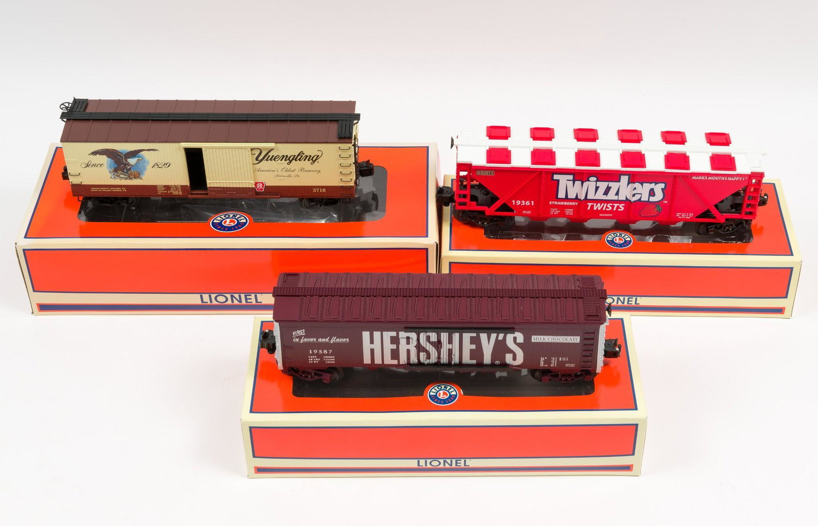 3 Lionel Branded Freight Cars with OBs: Includes 58260 LOTS Convention 2016 Yuengling double sided boxcar, 19361 Twizzlers Covered Quad Hopper, and 19587 Hershey's Chocolate Woodsided Reefer. Trucks show very little use, each with original 