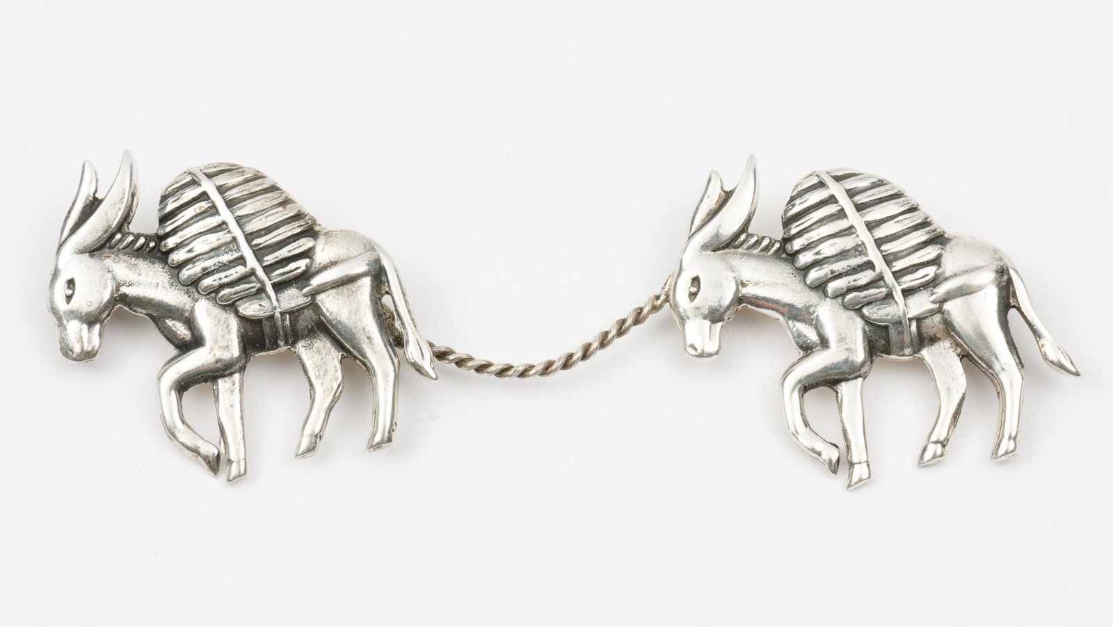 Los Castillo Sterling Donkey Brooch: With Eagle 15 mark and Los Castillo. Each brooch 1-1/4" wide; 2-3/4" wide as worn. MH. IMPORTANT: Before bidding, please read the terms and conditions. When you registered for the auction you agreed t