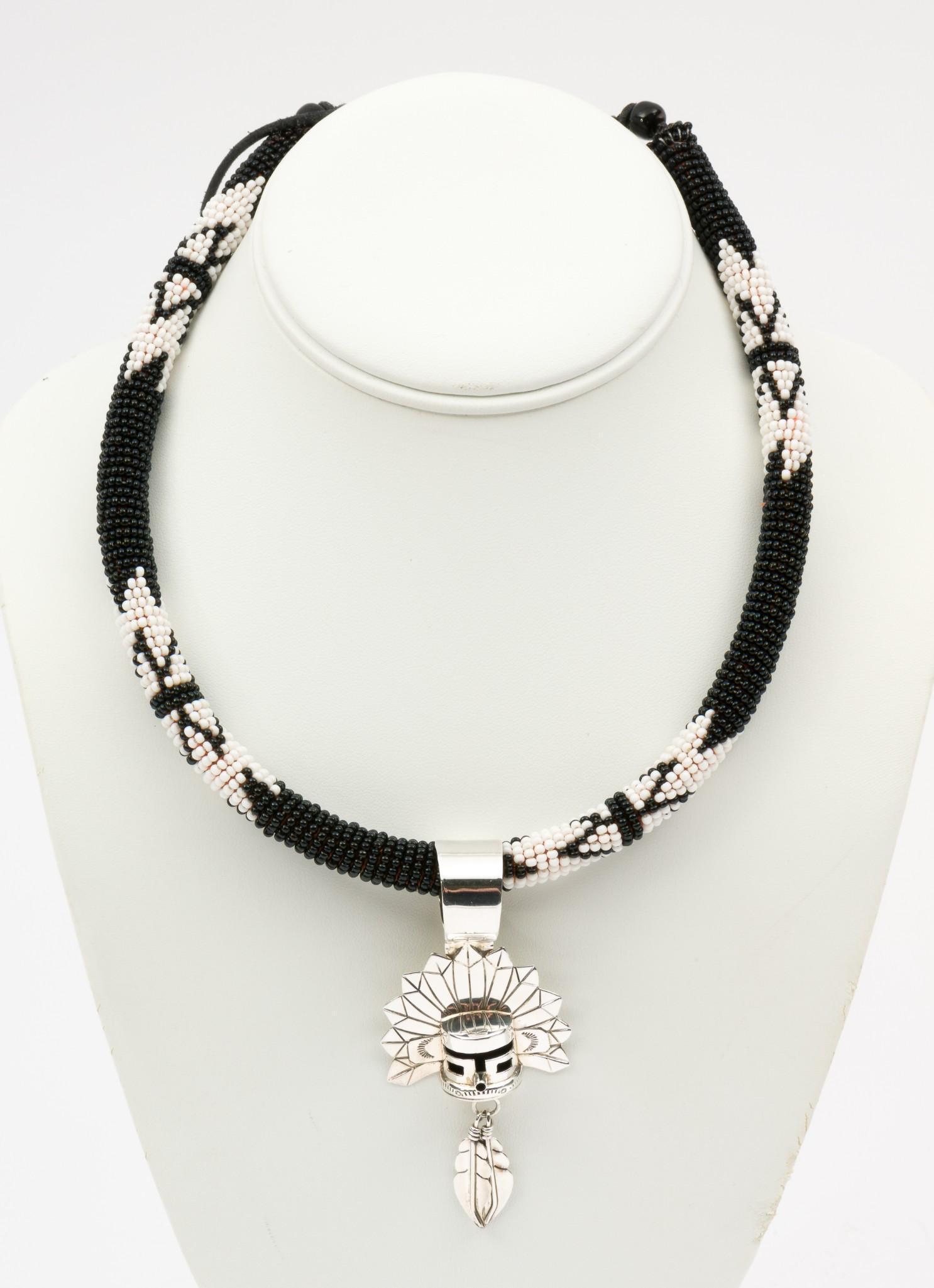 E Silago Navajo Sterling Pendant on Beaded Necklace: Navajo Morning Singer Kachina mask pendant marked sterling, signed E. Silago. With South African beaded necklace. Necklace 16" long; pendant 3" long. MH. IMPORTANT: Before bidding, please read the ter
