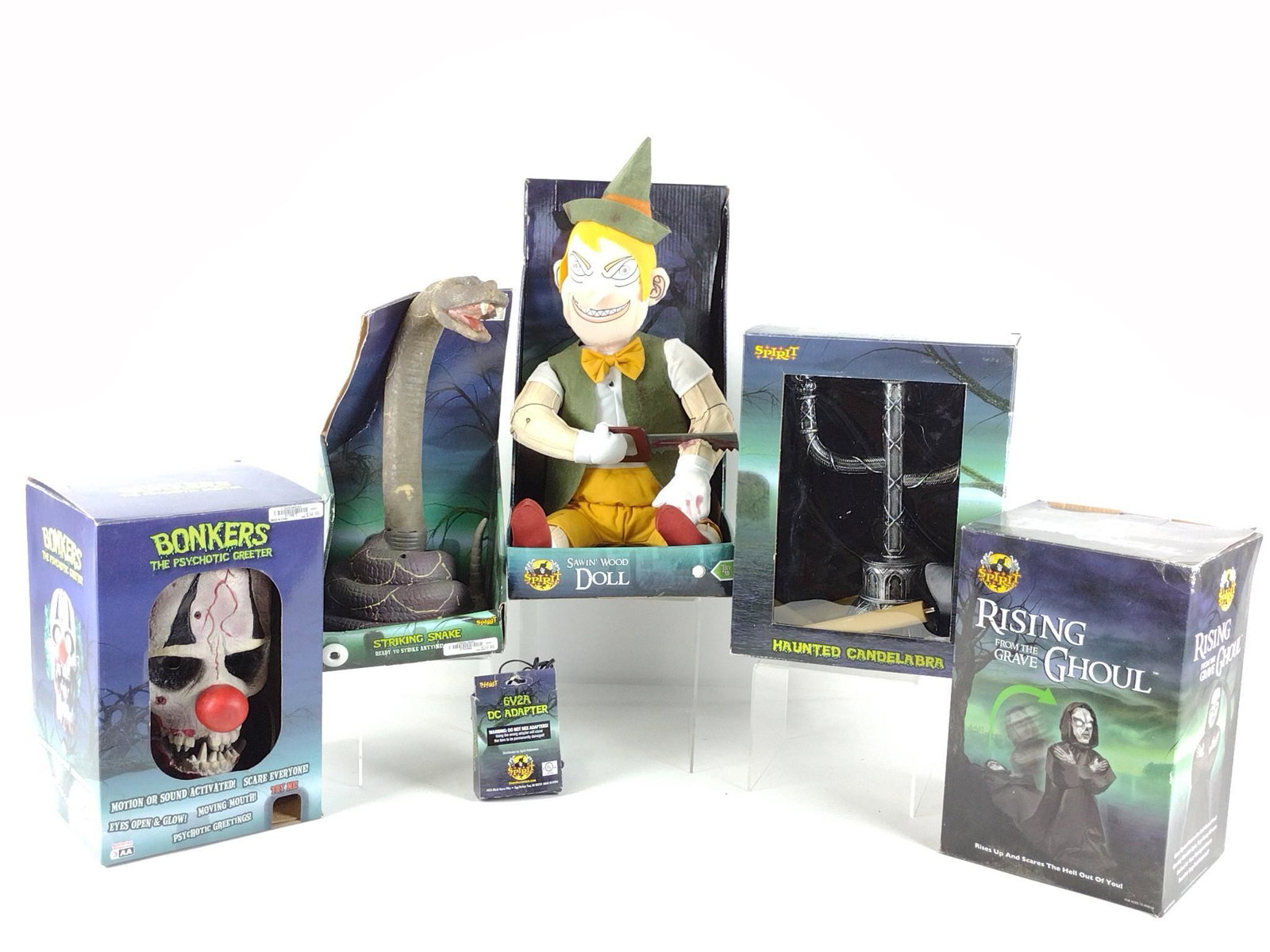 5 Spirit Halloween Novelty Items: Includes Rising From The Grave Ghoul, Haunted Candelabra, Bonkers The Psychotic Greeter, Sawin' Wood Doll, and Striking Snake. Also includes 6V2A DC Adapter. 11-3/4" to 17-1/2" high. Some boxes slight