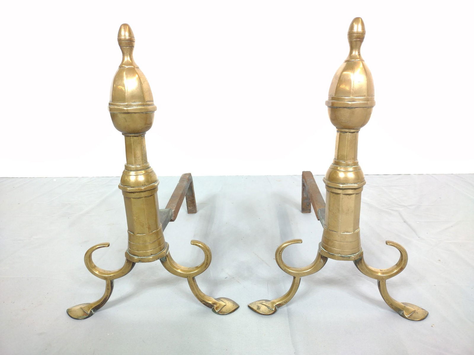 Pair Of Heavy Brass Andirons: 12" wide X 19" deep X 18" high. Both have some scratches and finish loss. MG. IMPORTANT: Before bidding, please read the terms and conditions. When you registered for the auction you agreed to these t