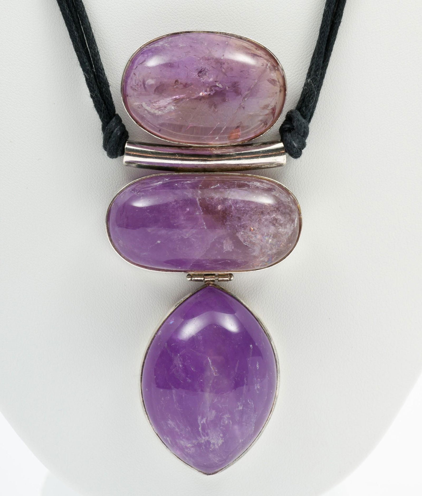 Amethyst Necklace: Three stone amethyst pendant on black silk cord. Pendant 4-1/8" long. Cord 18-1/2" long. DP. IMPORTANT: Before bidding, please read the terms and conditions. When you registered for the auction you ag
