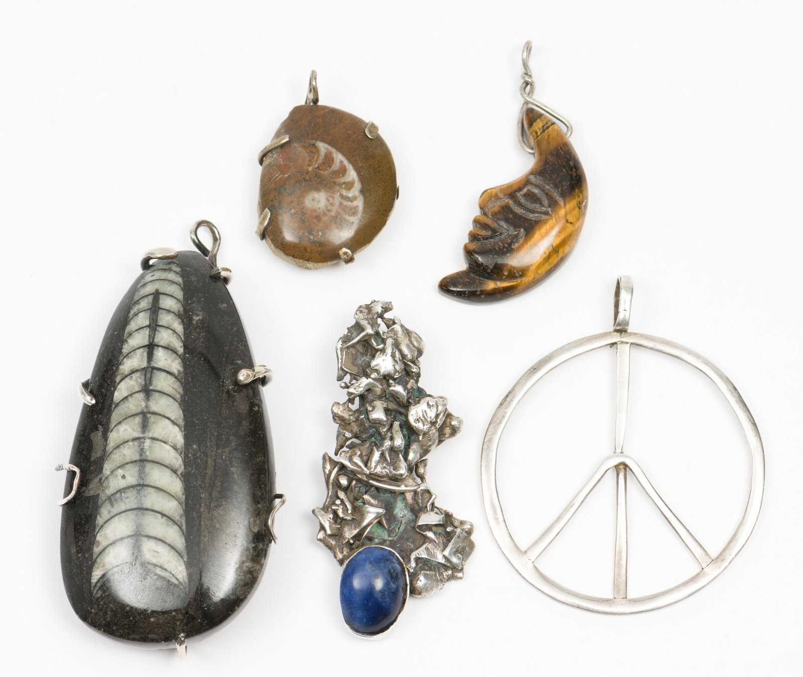 5 Pendants incl Fossil: Unmarked peace sign 2" diameter. Orthoceras pendant 3-1/2" long. Silver nugget and sodalite cabochon pendant 2-1/2" long. MH. IMPORTANT: Before bidding, please read the terms and conditions. When you