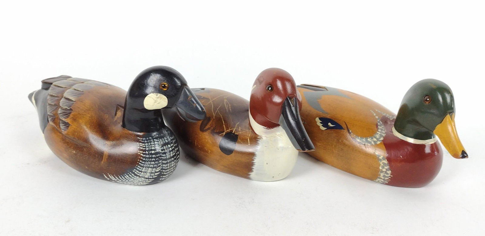 3 Duck Decoys: All unsigned. 9-1/2" to 11" long x 4" high. RM IMPORTANT: Before bidding, please read the terms and conditions. When you registered for the auction you agreed to these terms and will be required to co