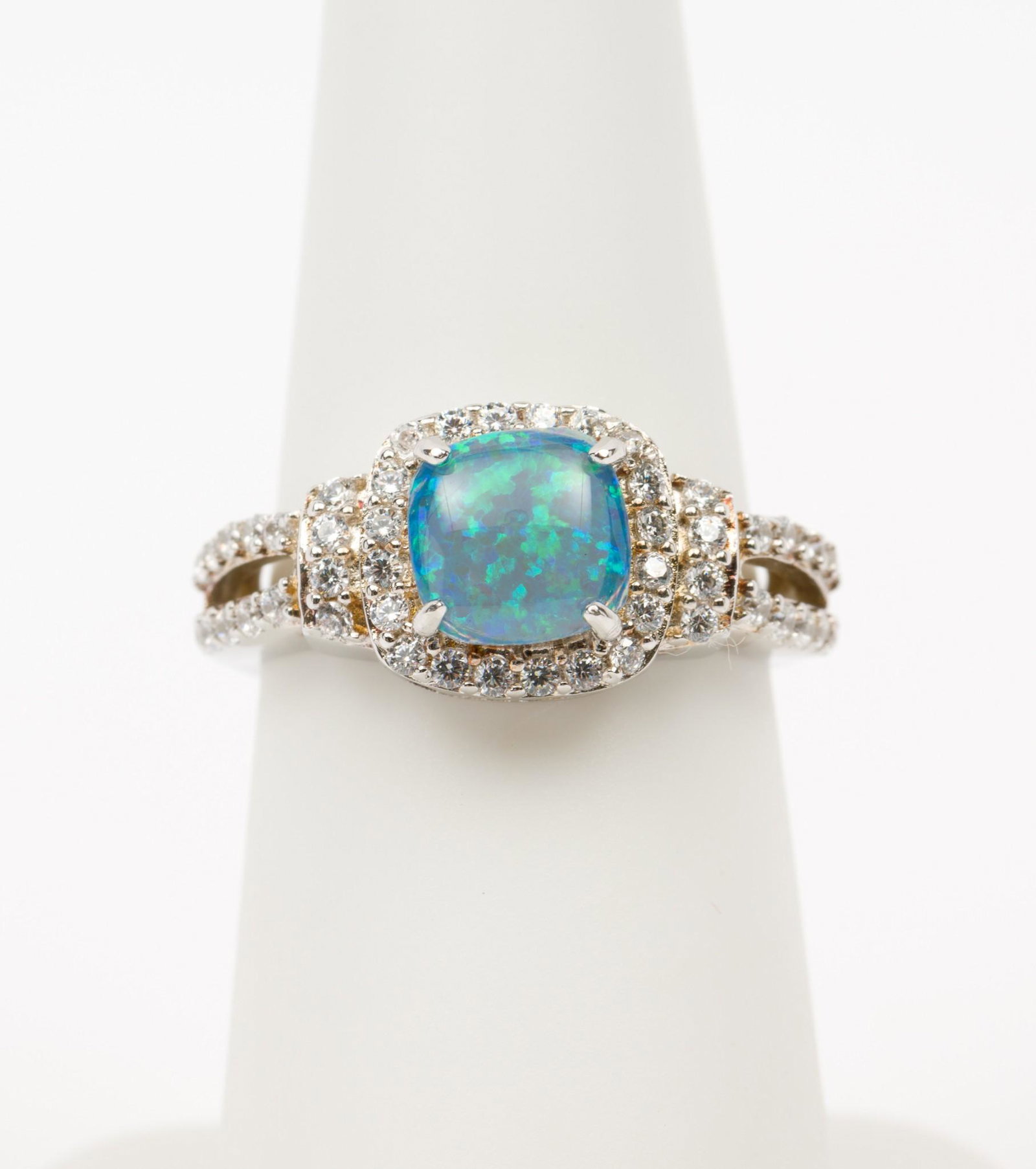 Sterling CZ and Opal Ring: Sterling (stamped 925) setting with blue opal cushion cut cabochon and CZ accents. Size 6. MH/EK IMPORTANT: Before bidding, please read the terms and conditions. When you registered for the auction yo