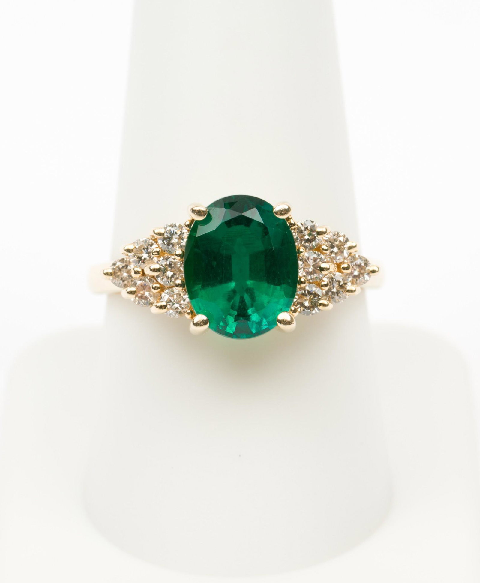 14K Gold & Gemstone Ring: 14k stamped ring set with oval cut synthetic emerald and twelve .03 carat each round brilliant cut diamonds. Total diamond weight approximately .36 carats. Clarity I1, Color H-I. 2.9 dwt. Size 9. EK I