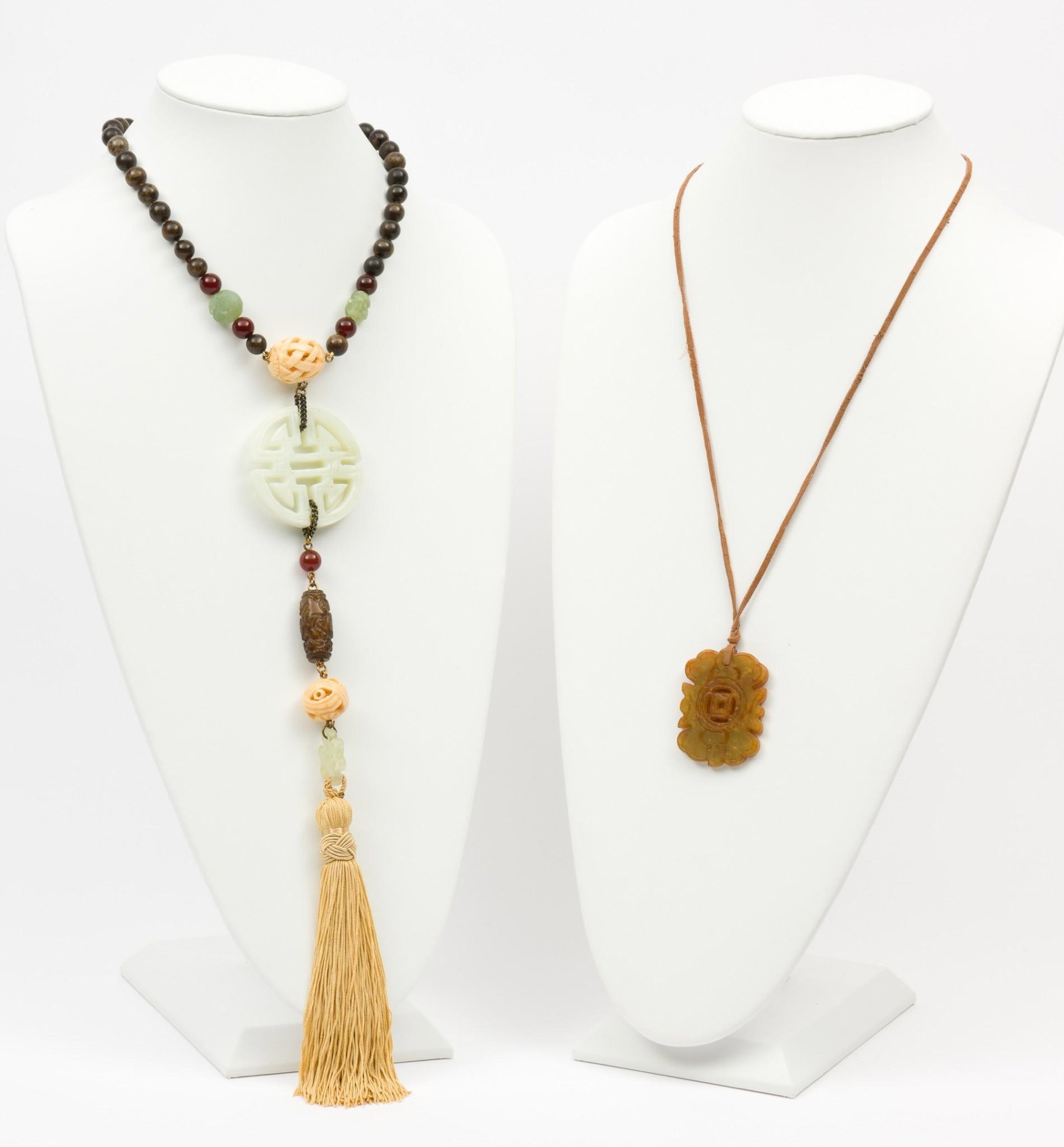 2 Jade and Hardstone Asian Necklaces: Bead necklace 16" long with 12" pendants and tassel. Leather cord 24" long with 2" pendant. MH. IMPORTANT: Before bidding, please read the terms and conditions. When you registered for the auction you