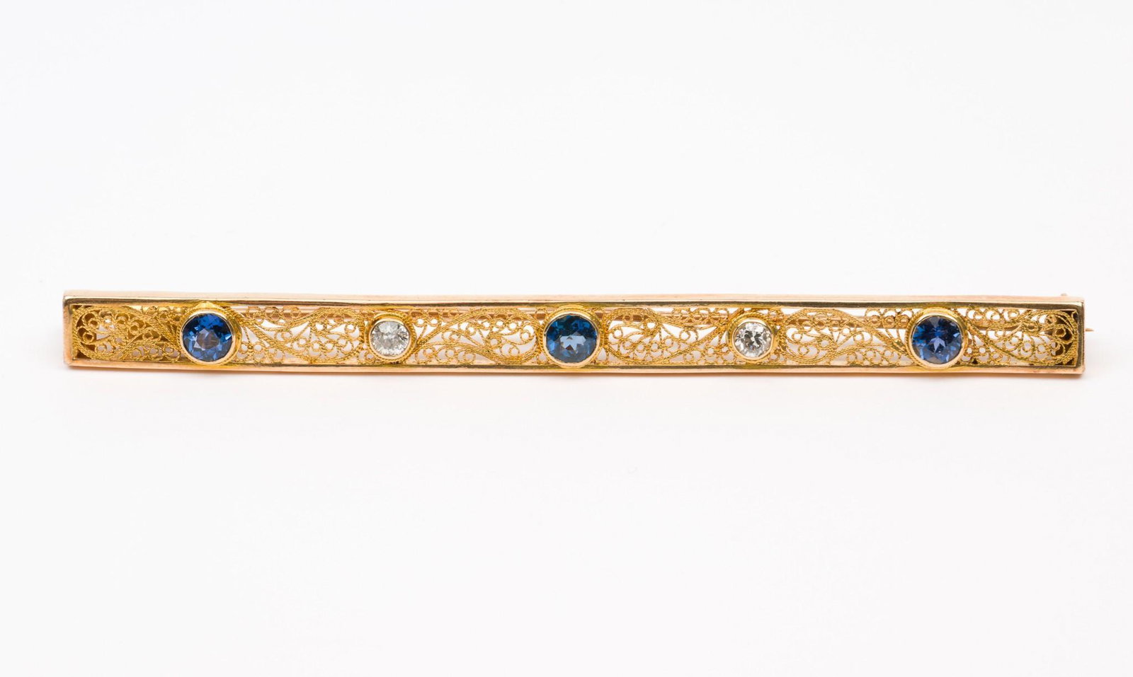 10K Gold, Diamond & Sapphire Filigree Bar Pin: Marked 10k filigree bar pin bezel set with three blue sapphires and two .10 carat each round brilliant cut diamonds (one modified). Clarity SI2, Color G-H. 3-1/3" long. 5.0 dwt. MH/EK IMPORTANT: Befor