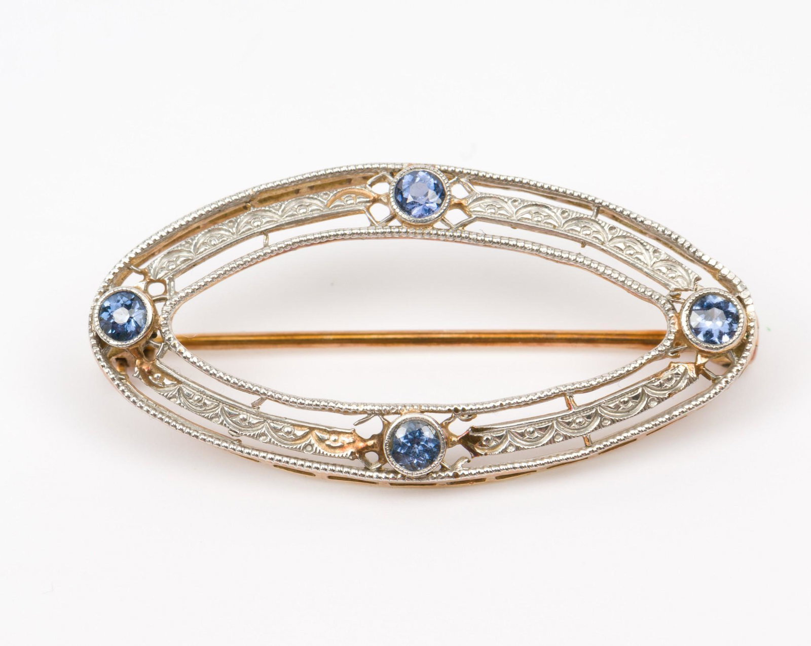 14K Gold & Sapphire Pin: Stamped 14k gold filigree pin with platinum top set with four round cut sapphires. 1-1/3" wide. 1.9 dwt. MH/EK IMPORTANT: Before bidding, please read the terms and conditions. When you registered for 
