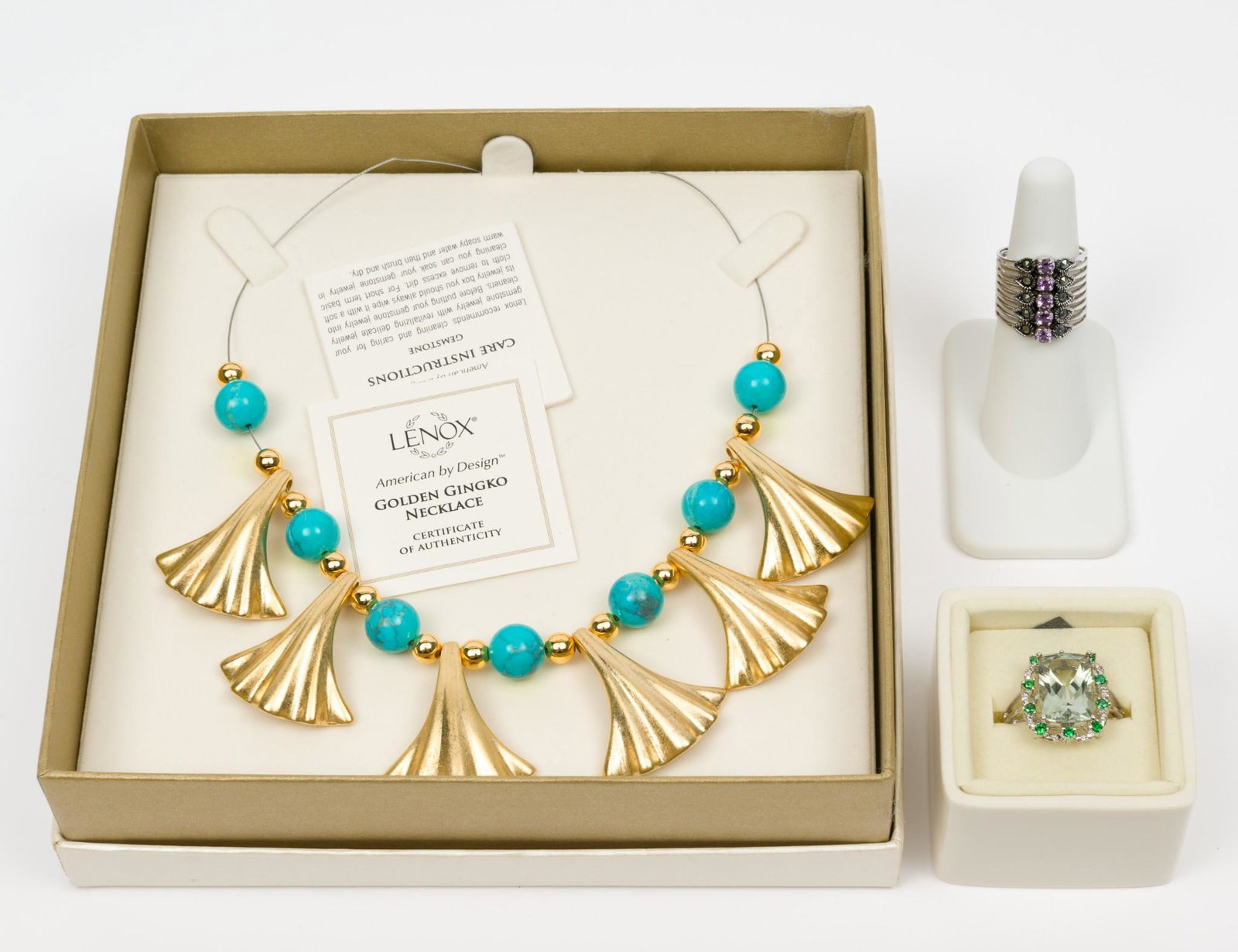Lenox Jewelry, 2 Rings and 1 Necklace: Golden Ginko necklace 16" long with 1-1/4" long leaves. Rhodium plated amethyst ring size 6, 2/3" wide; in original box. Green quartz cocktail ring size 10 2-3" wide. In Lenox ring box and original ou