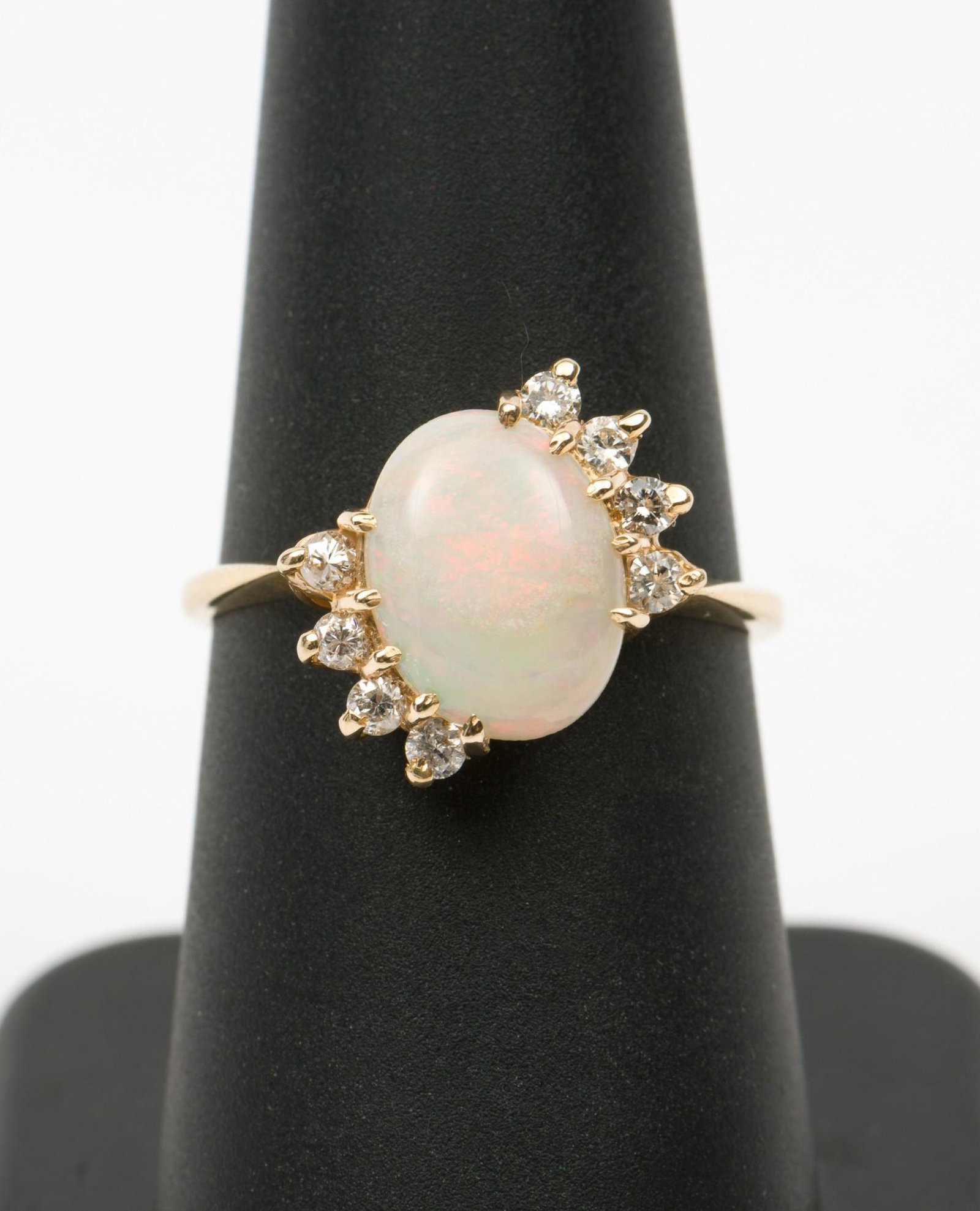 14K Opal and Diamond Ring: 14k stamped setting with .61 carat (9mm x 6mm) opal cabochon and eight .02 carat each round brilliant cut diamonds. Clarity I1, Color H-I. 2.1 dwt. Size 7.5. MH/EK IMPORTANT: Before bidding, please re