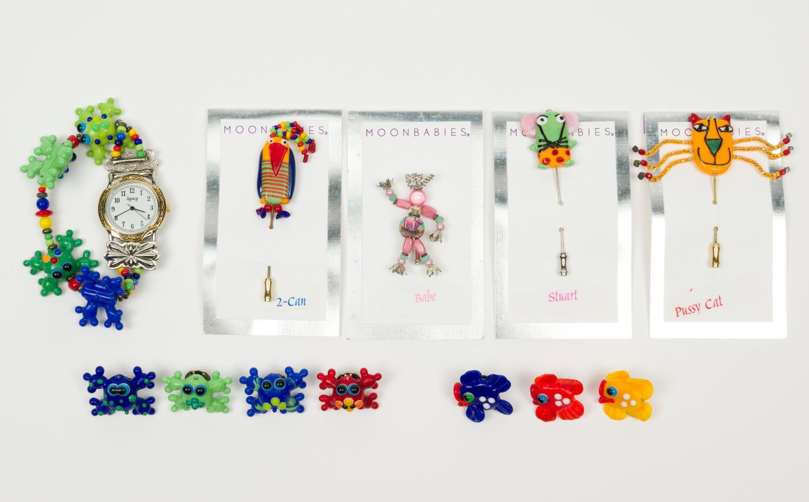 Moonbabies Pins and Watch: Four pins on cards 1" to 2" long. Seven frog and fish pins 1" wide. Watch with 7" band 1-1/3" lug to lug. MH. IMPORTANT: Before bidding, please read the terms and conditions. When you registered for t