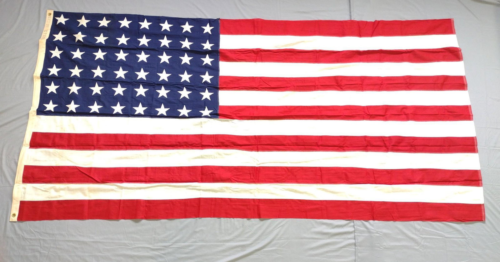 48 Star Flag: 9' 3" wide x 4' 7-1/2" high. Some staining throughout. DP. IMPORTANT: Before bidding, please read the terms and conditions. When you registered for the auction you agreed to these terms and will be re