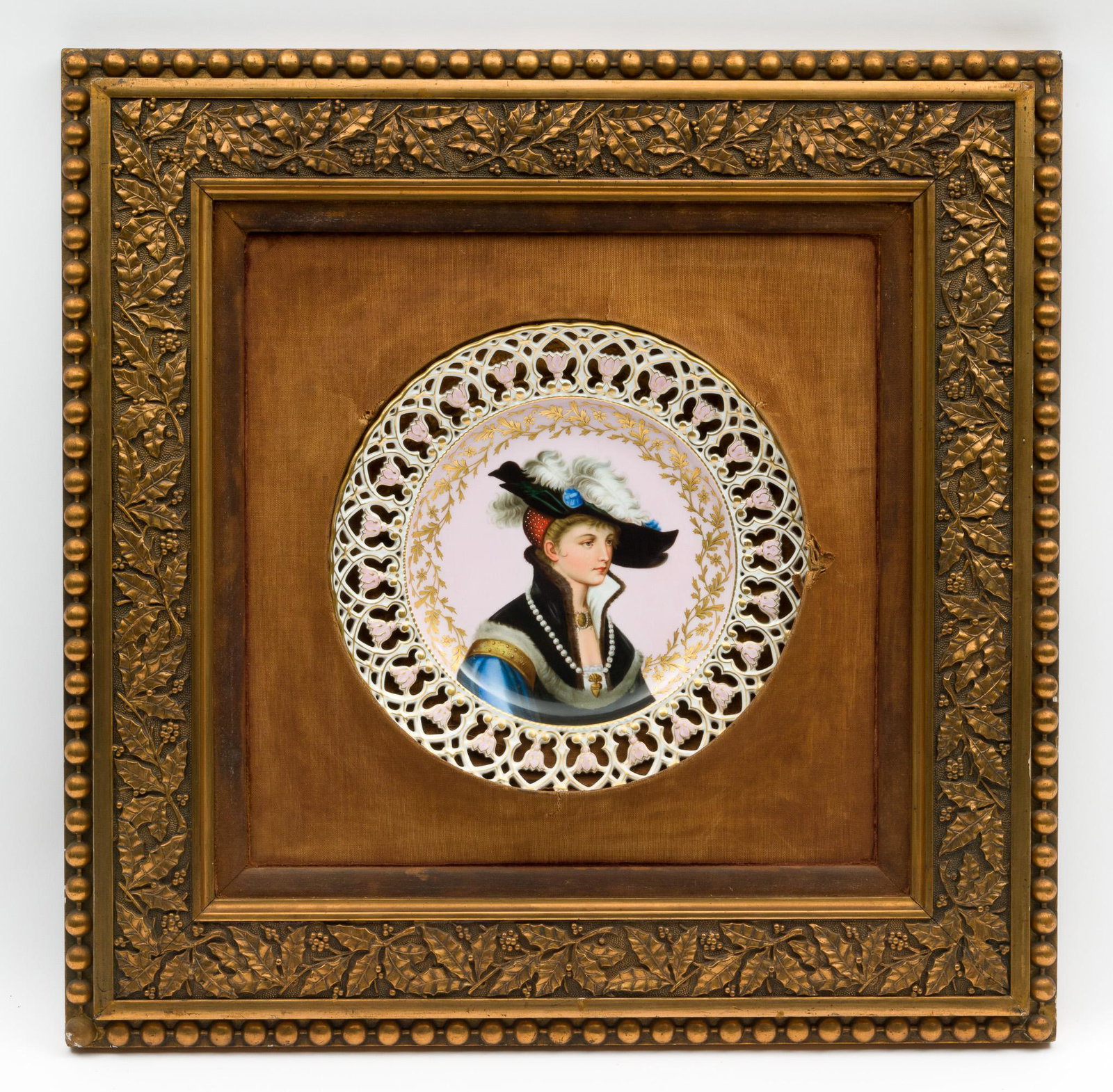 Hand Painted Cabinet Portrait Plate: DESCRIPTION: Hand painted cabinet portrait plate. Early 20th century. Portrait at center of a woman in robes and feathered hat and surrounded by gilt leaves. Reticulated floral edge. Unsigned. To back