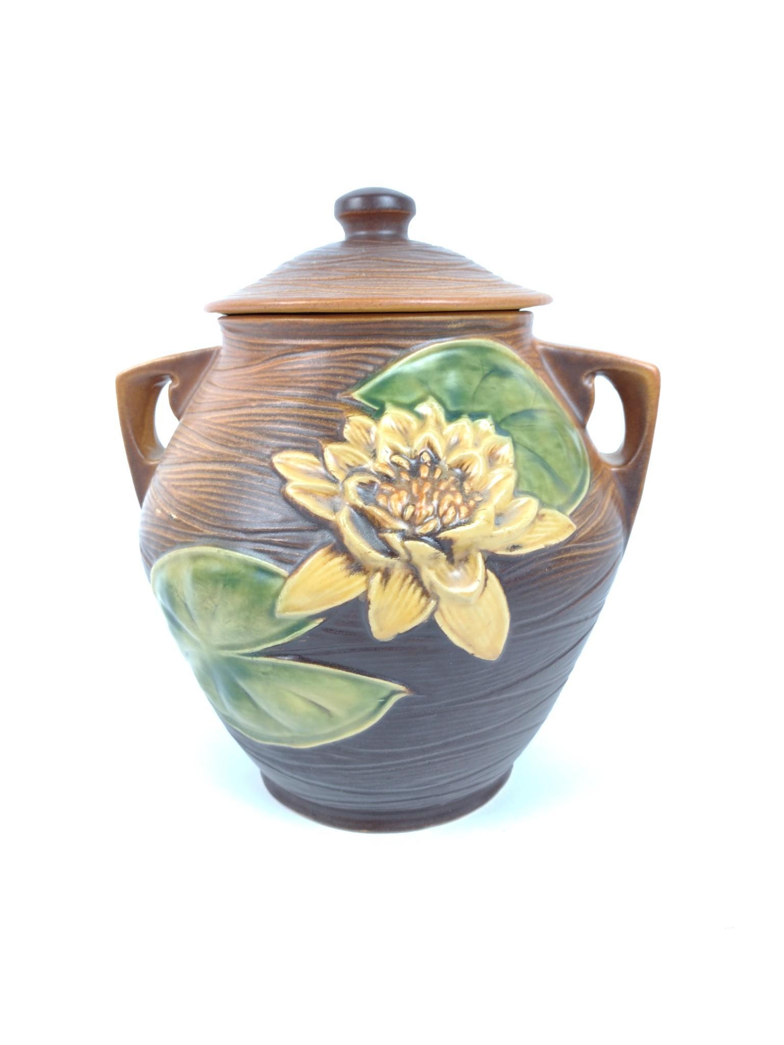 10-1/2" Roseville Water Lily Cookie Jar: Number 1-8. 9" wide x 10-1/2" high. Minor loss to front finish. JB IMPORTANT: Before bidding, please read the terms and conditions. When you registered for the auction you agreed to these terms and wi