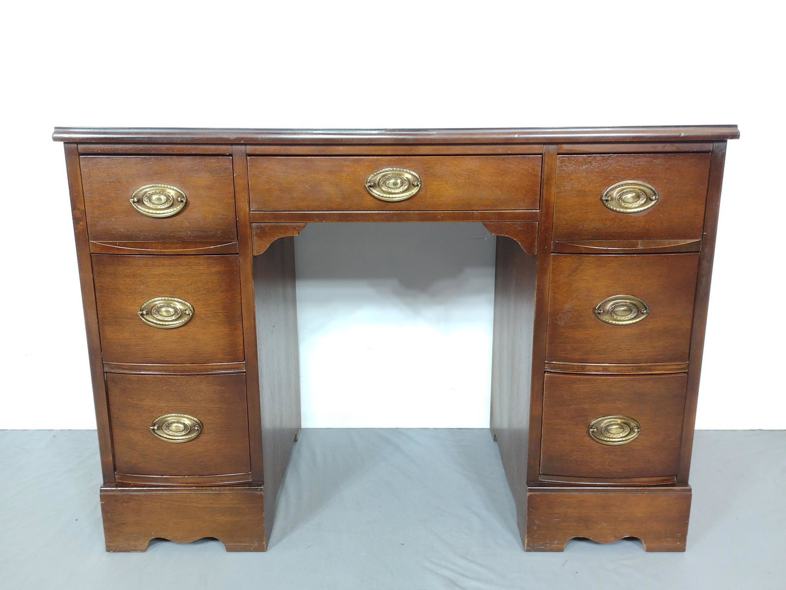 Bassett kneehole Desk: 42" wide X 19-1/2" deep X 29-3/4" high. Has some light scratches to desk top and around base. MG. IMPORTANT: Before bidding, please read the terms and conditions. When you registered for the auction y