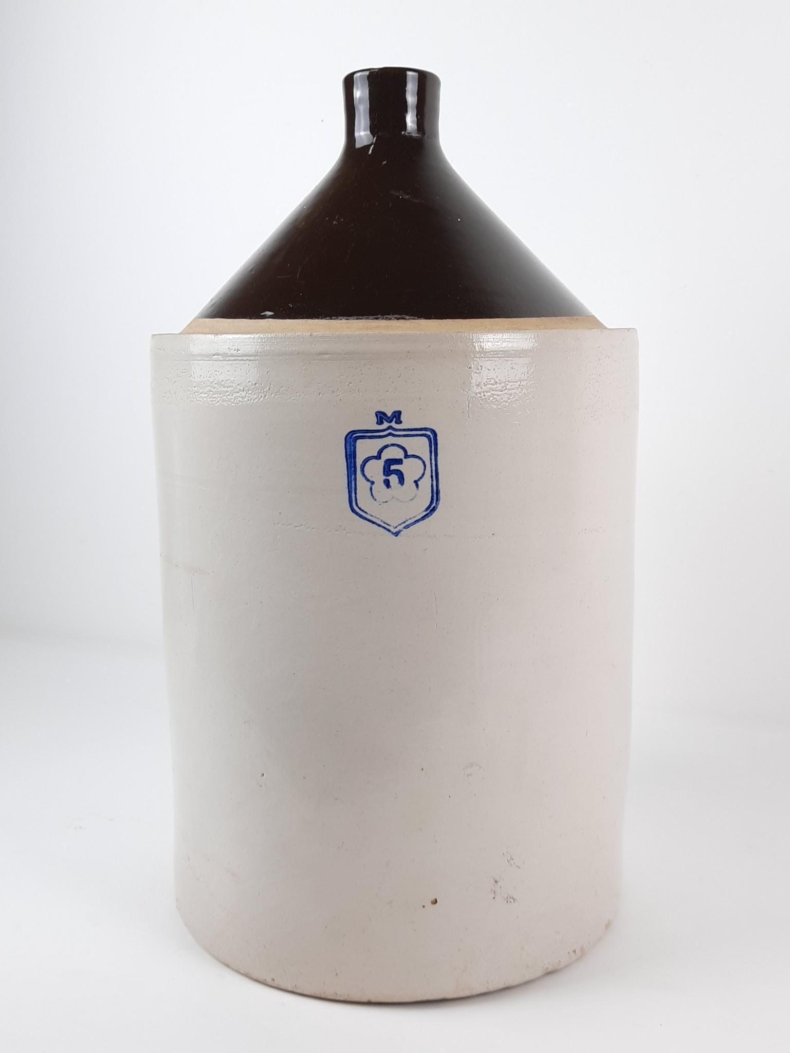 5 Gallon Nelson McCoy Stoneware Jug: 11" diameter x 20" high. Loss to back. LR IMPORTANT: Before bidding, please read the terms and conditions. When you registered for the auction you agreed to these terms and will be required to comply 