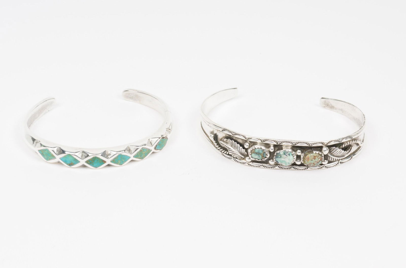 2 Native American Cuff Bracelets: 1) Feather decorated with turquoise. Interior 1-1/2" x 2-1/4", 1/2" wide. 2) Inlaid turquoise in diamond pattern. Interior 1-1/2" x 2", 1/4" wide. EK IMPORTANT: Before bidding, please read the terms a
