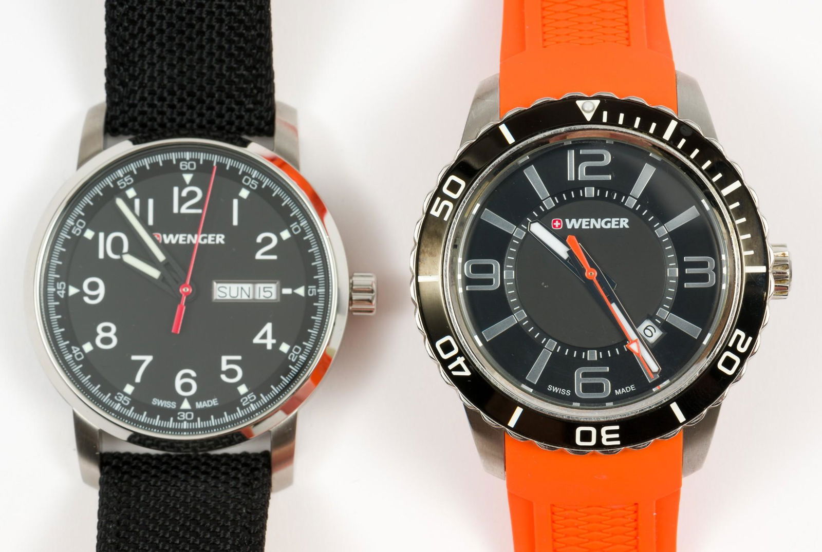 2 Wenger Wristwatches: Sapphire-coated crystal, 100M, marked 0851.17, with orange band. Case length 2", lug to lug. Sapphire-coated crystal, 01.541.105, water resistant, with black band. Case length 2", lug to lug. LM IMPOR