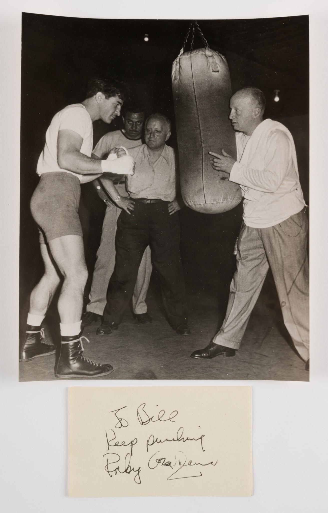 Rocky Graziano Autograph and Photo: Rocky Graziono Autograph "To Bill Keep punching" on 3" x 5" card. With 8" x 10" photo of him training. MH. IMPORTANT: Before bidding, please read the terms and conditions. When you registered for the 