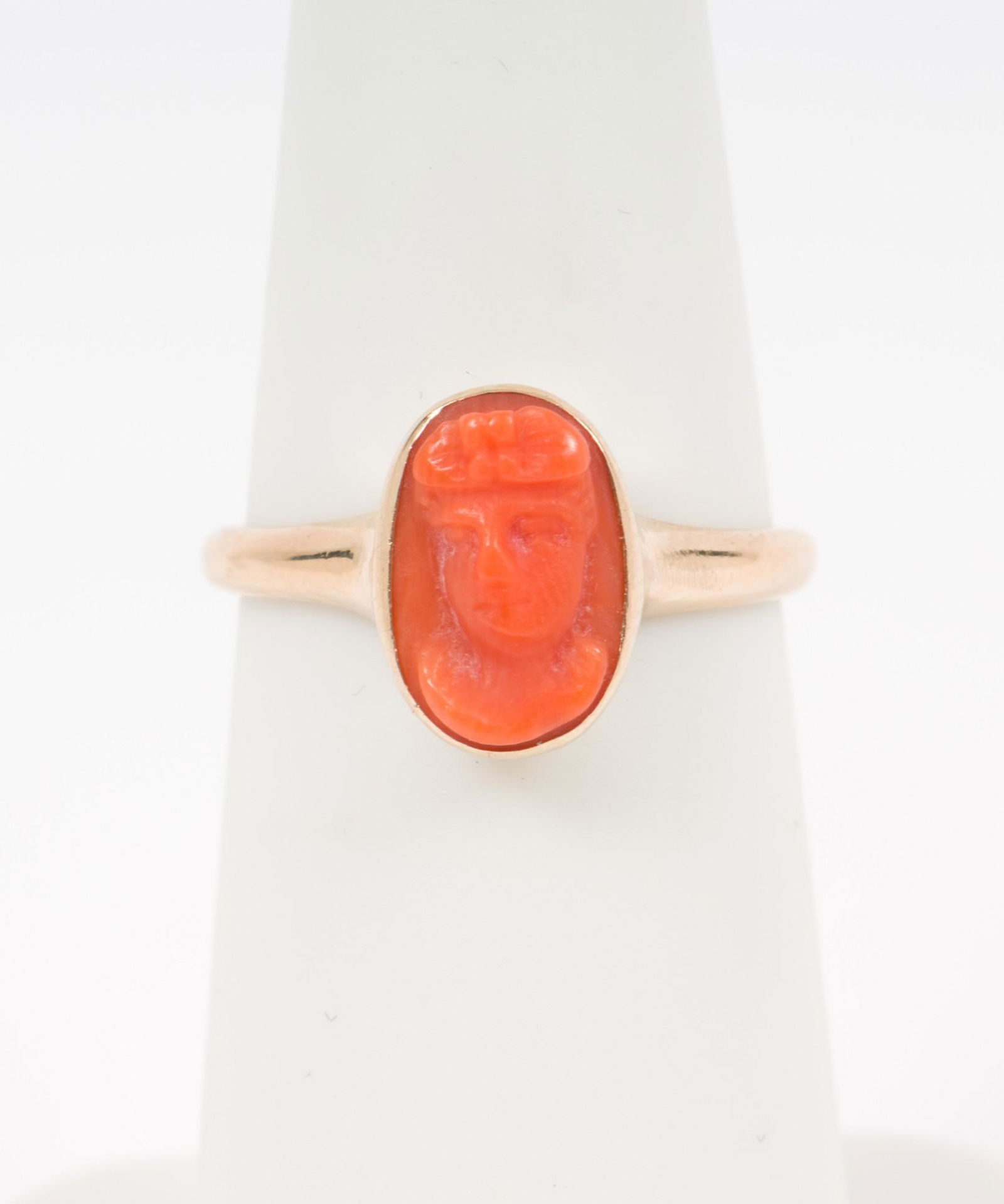 10k Gold And Coral Ring: Stamped 10k. Size 4-1/2. 1/4" wide. 1.1 dwt. IMPORTANT: Before bidding, please read the terms and conditions. When you registered for the auction you agreed to these terms and will be required to comp