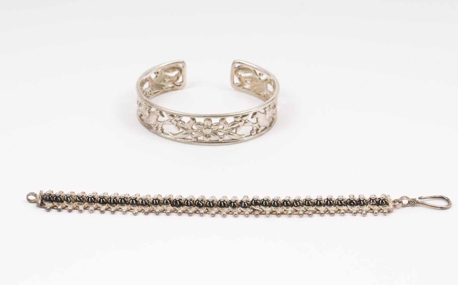 2 Sterling Bracelets: Cuffmarked 925. Cuff 2-1/2" interior diameter. 5/8" wide. Chain 6" long by 1/2" wide. AJ/MH IMPORTANT: Before bidding, please read the terms and conditions. When you registered for the auction yo