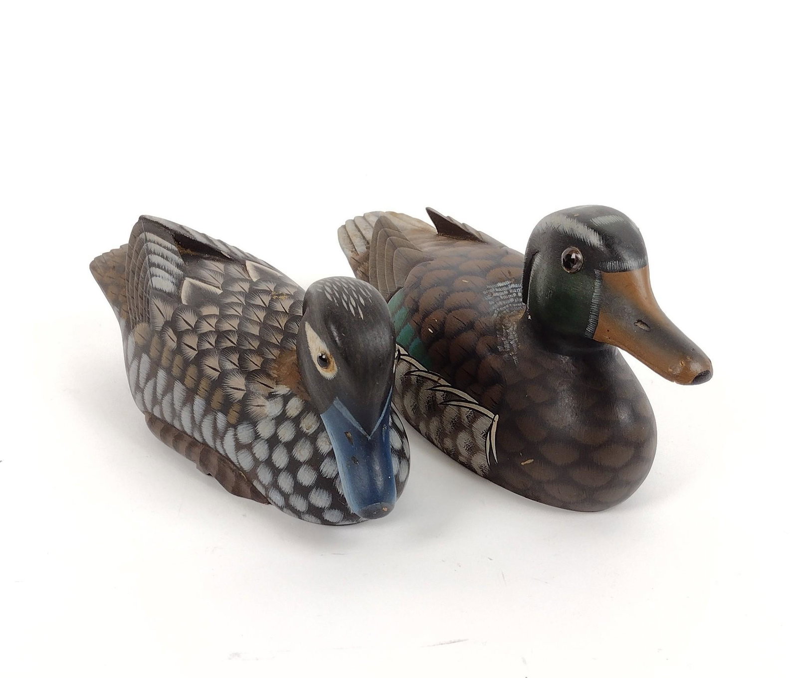 2 Wooden Duck Decoys: Unsigned. 3" to 3-1/2" wide X 8-3/4" to 10" long. MEG IMPORTANT: Before bidding, please read the terms and conditions. When you registered for the auction you agreed to these terms and will be require