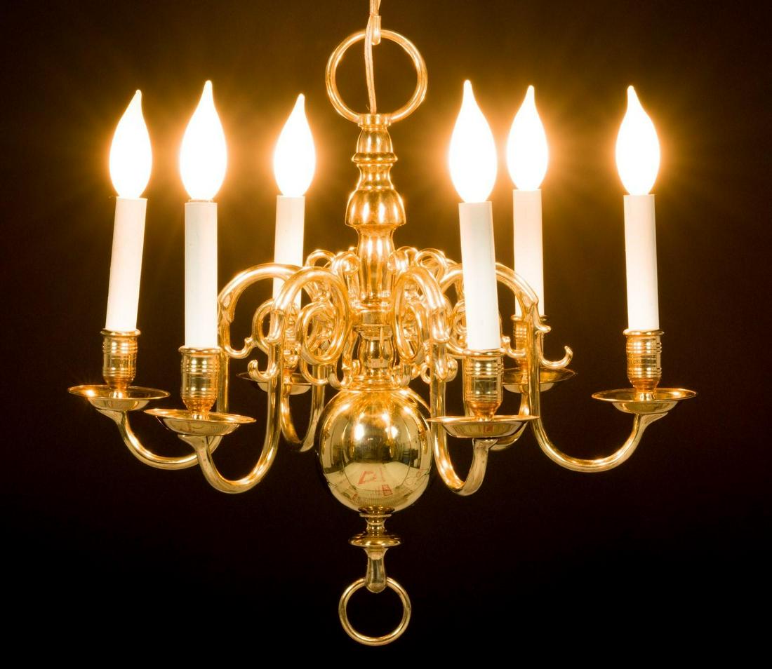 Brass Virginia Metalcraft Williamsburg Chandelier: DESCRIPTION: Brass six-arm Virginia Metal Crafters Williamsburg-style chandelier. Electrified. Arms with scroll design. Bulbous to bottom of column. With Virginia Metal Crafters stamp and "Virginia Me