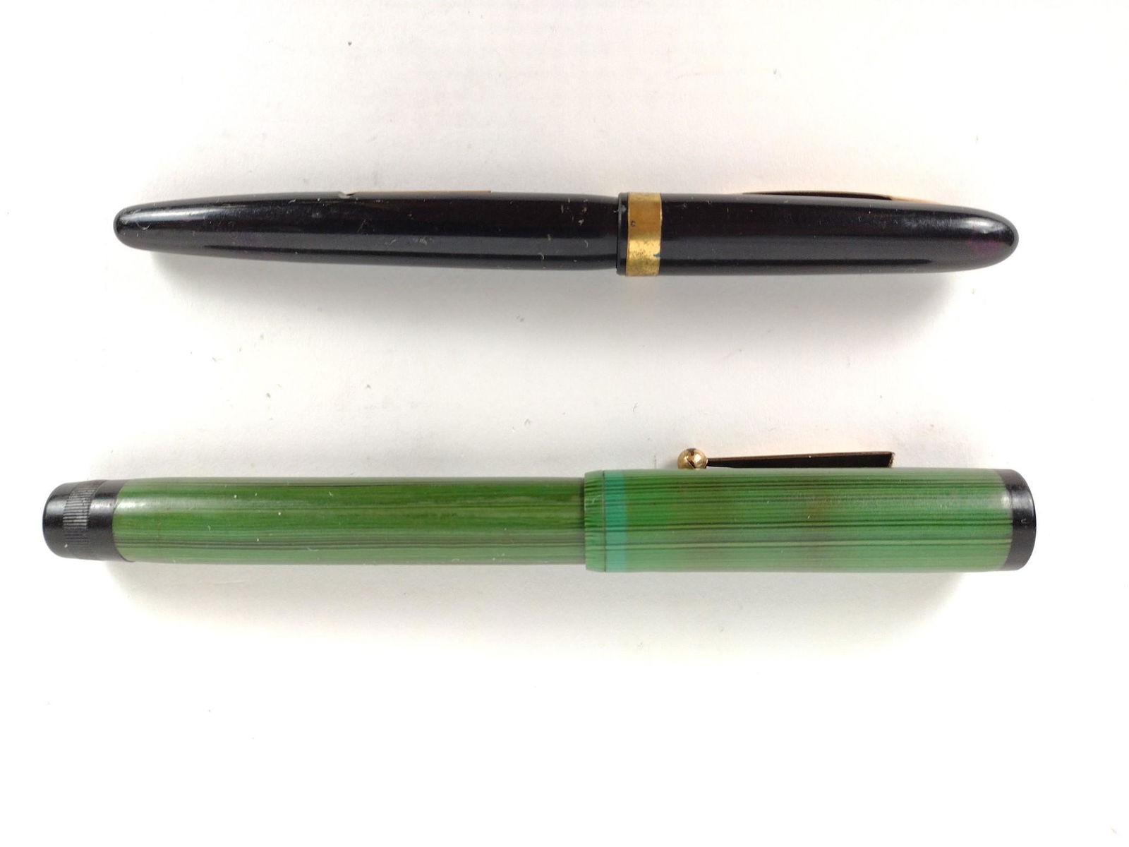 2 Fountain Pens: Green Ingersoll, black Eversharp. 5-1/4" to 5-1/2" long. JB IMPORTANT: Before bidding, please read the terms and conditions. When you registered for the auction you agreed to these terms and will be r