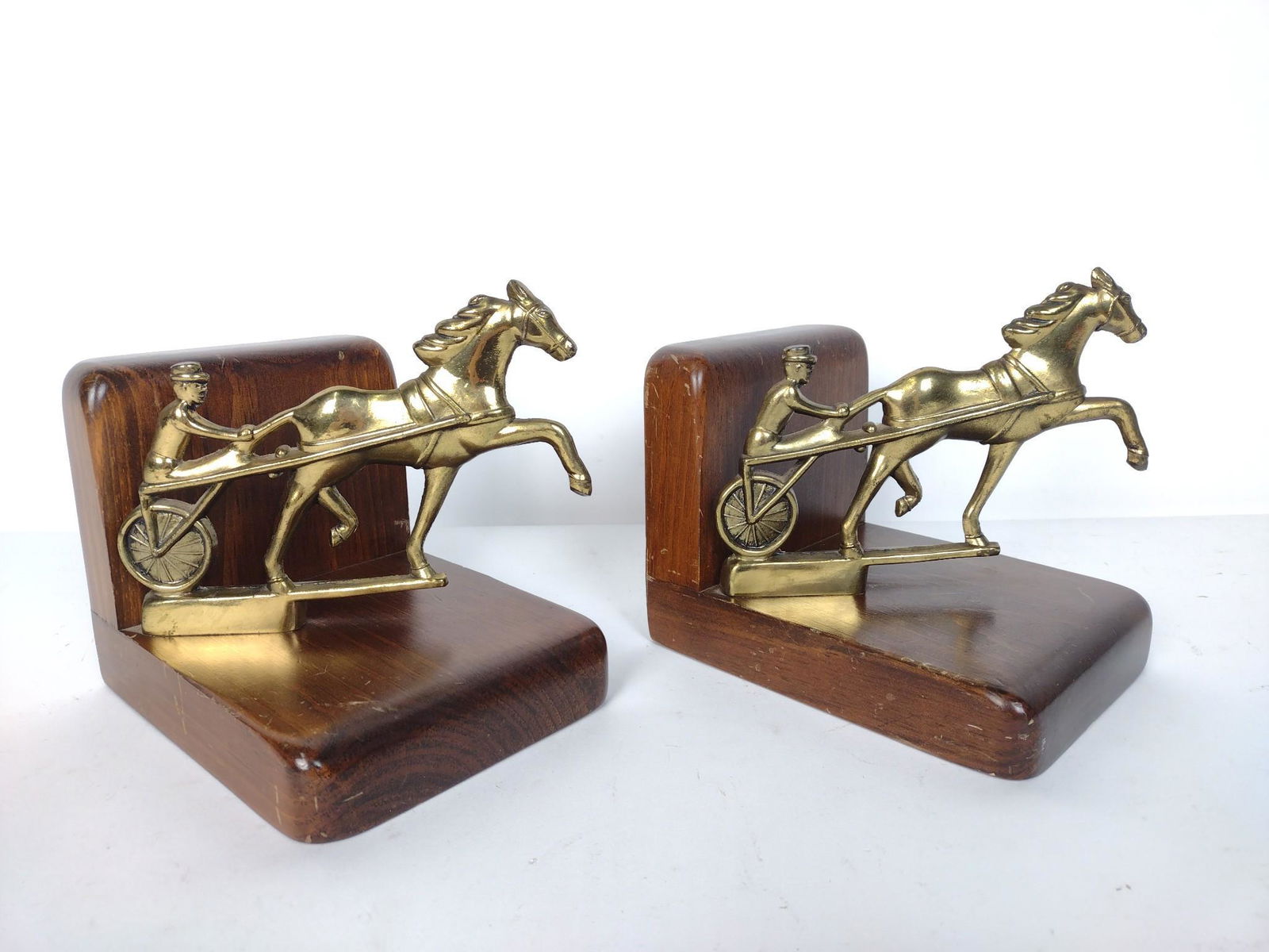 Pair Brass/Wood Horse Racing Bookends By Cornwall: Each 5-1/2" wide X 7" deep X 7" high. MG. IMPORTANT: Before bidding, please read the terms and conditions. When you registered for the auction you agreed to these terms and will be required to comply