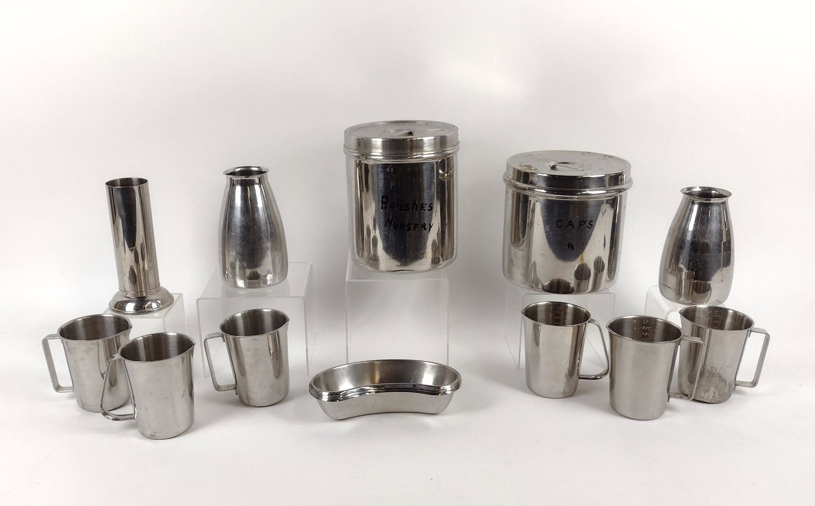 14 Stainless Steel Medical Accessories: Includes canisters, instrument holders, trays, and more. 1-1/2" to 8" high. MEG IMPORTANT: Before bidding, please read the terms and conditions. When you registered for the auction you agreed to these