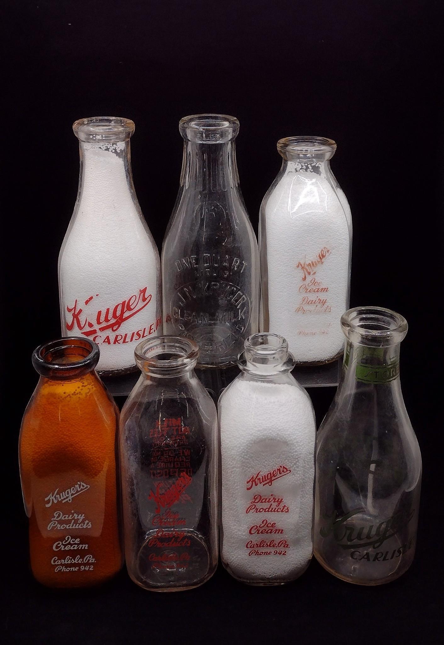 7 Kruger Dairy Carlisle, PA Bottles: Includes (4) one quart bottles with red, white and brown lettering, J. N. Kruger one quart round bottle with embossed lettering, Kruger 5 cent store bottle with green lettering, and round one quart bo