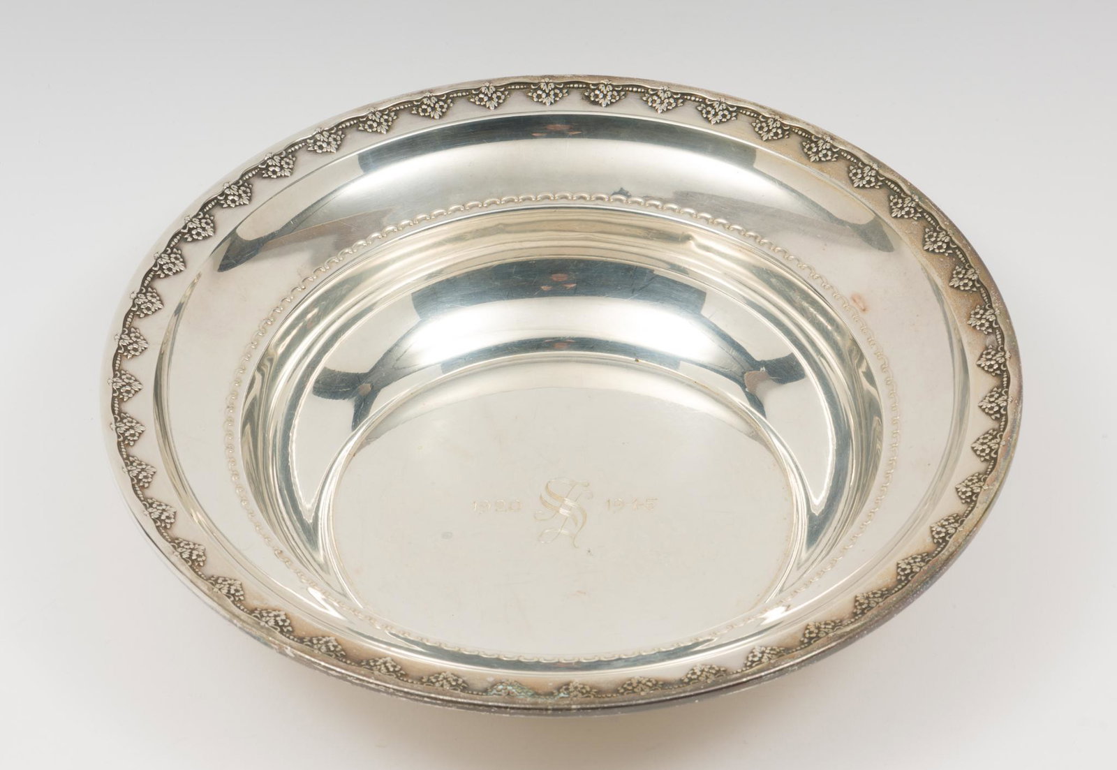 Rogers Sterling Bowl With Ornate Edge: Ornate top edge and inner edge with repousse inscribed 1920/1945 with a monogrammed S. 10" diam. 2-1/4" H. 9.98 ozt. DC/ML IMPORTANT: Before bidding, please read the terms and conditions. When you reg