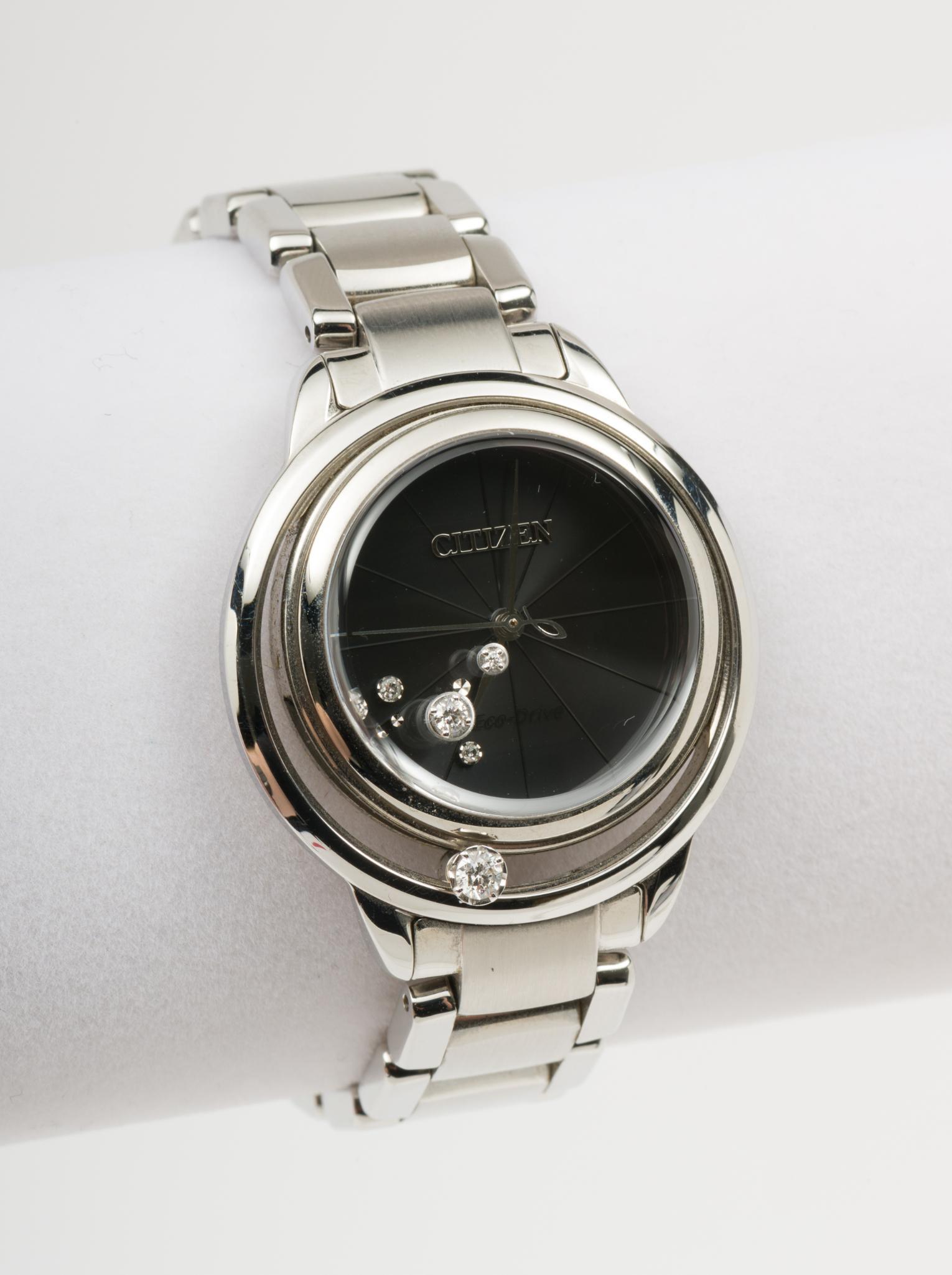Citizen Eco-Drive .17 CTW Diamond Wristwatch: Citizen floating diamond wristwatch. Three diamonds set to case and crystal, each .10 carat, .05 carat, and .02 carat. Clarity I1, Color H-I. Stainless steel case and band. 1-5/8" lug to lug. Running.