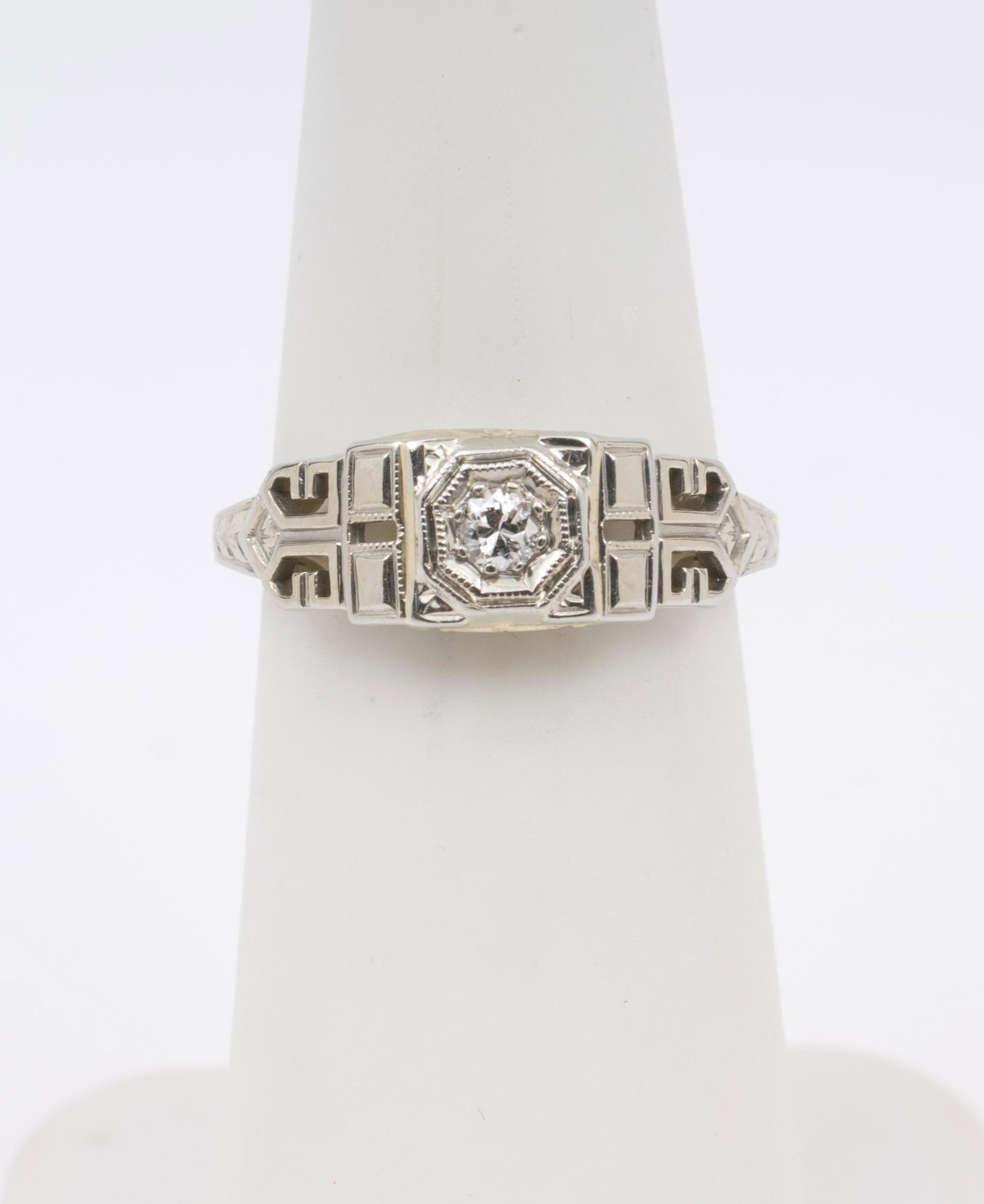 18K White Gold and Diamond Ring: Stamped (partially legible) and tested 18k white gold antique setting with approximately .10 carat round brilliant cut diamond. Clarity SI2, Color H-I. Size 4.5. 1.5 dwt. EK/ML IMPORTANT: Before biddi
