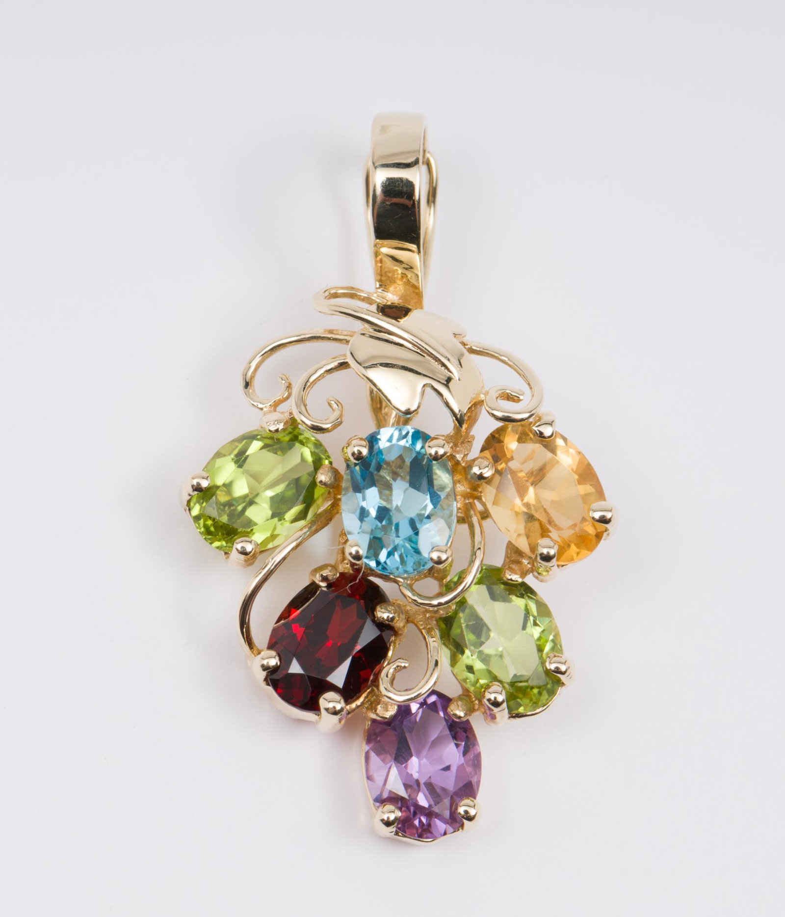 14K Gold and Gemstone Enhancer: Stamped 14k. Six oval cut multi color gemstones including peridot, blue topaz, citrine, garnet, and amethyst. 3/4" x 1-1/4". 2.4 dwt. EK/ML IMPORTANT: Before bidding, please read the terms and conditi