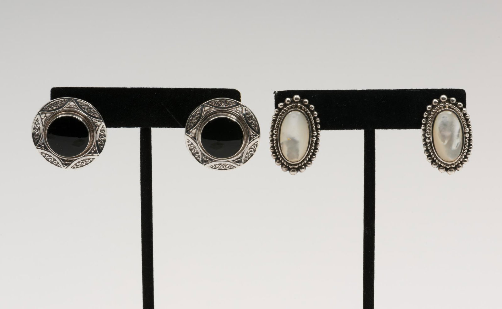 2 Pairs Silver Earrings: Pierced. Includes sterling with mother of pearl and silver with black glass. 1" to 1-1/8". EK/ML IMPORTANT: Before bidding, please read the terms and conditions. When you registered for the auction yo