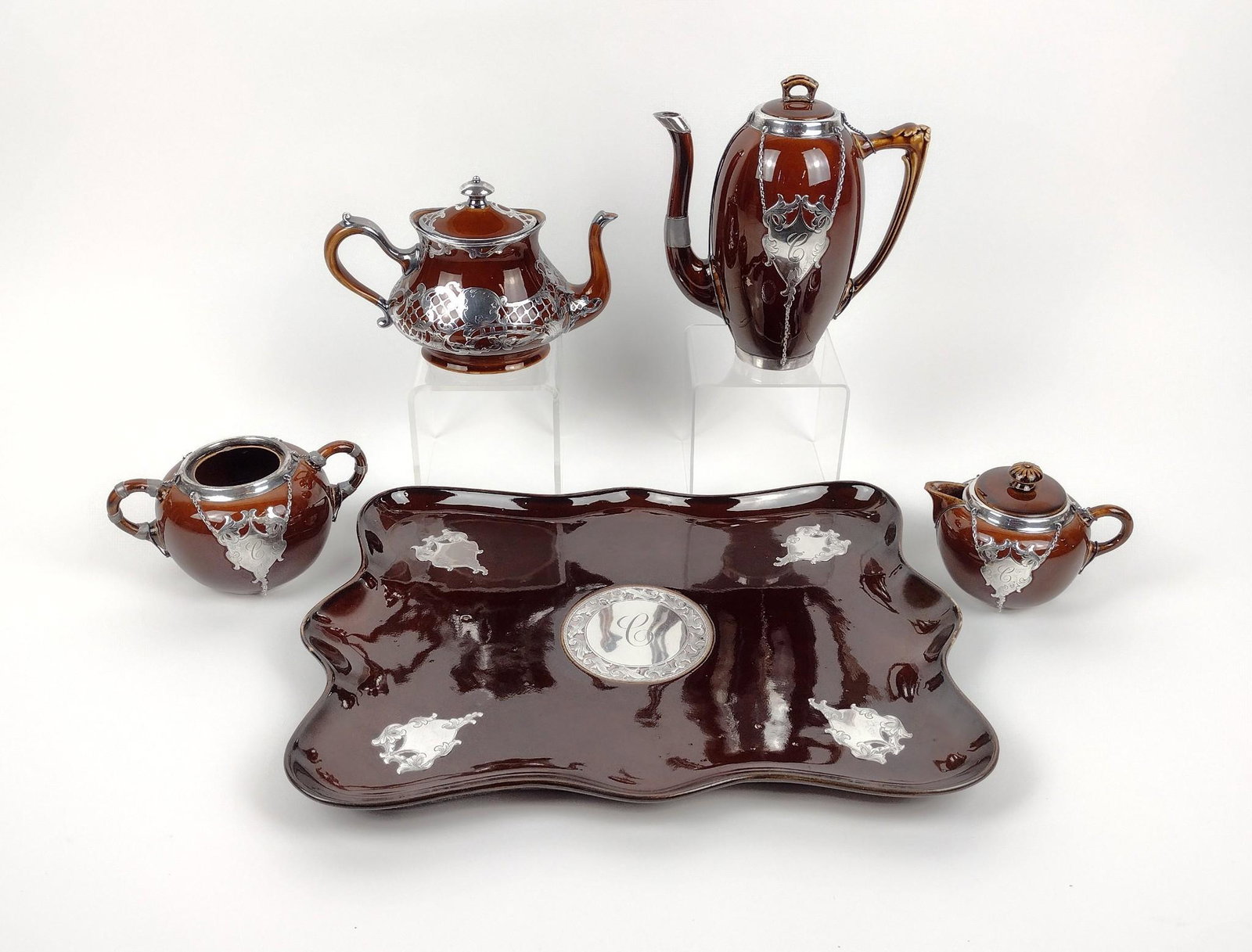 5 Pc Crown Staffordshire Tea Set with Sterling Overlay: Tray: 13-1/2" wide. 3-1/4" to 7-1/2" high. Chip to lid and spout of one teapot. MEG Provenance: From the estate of Mary Trost who last resided in the multi generational family home located in Clarks V