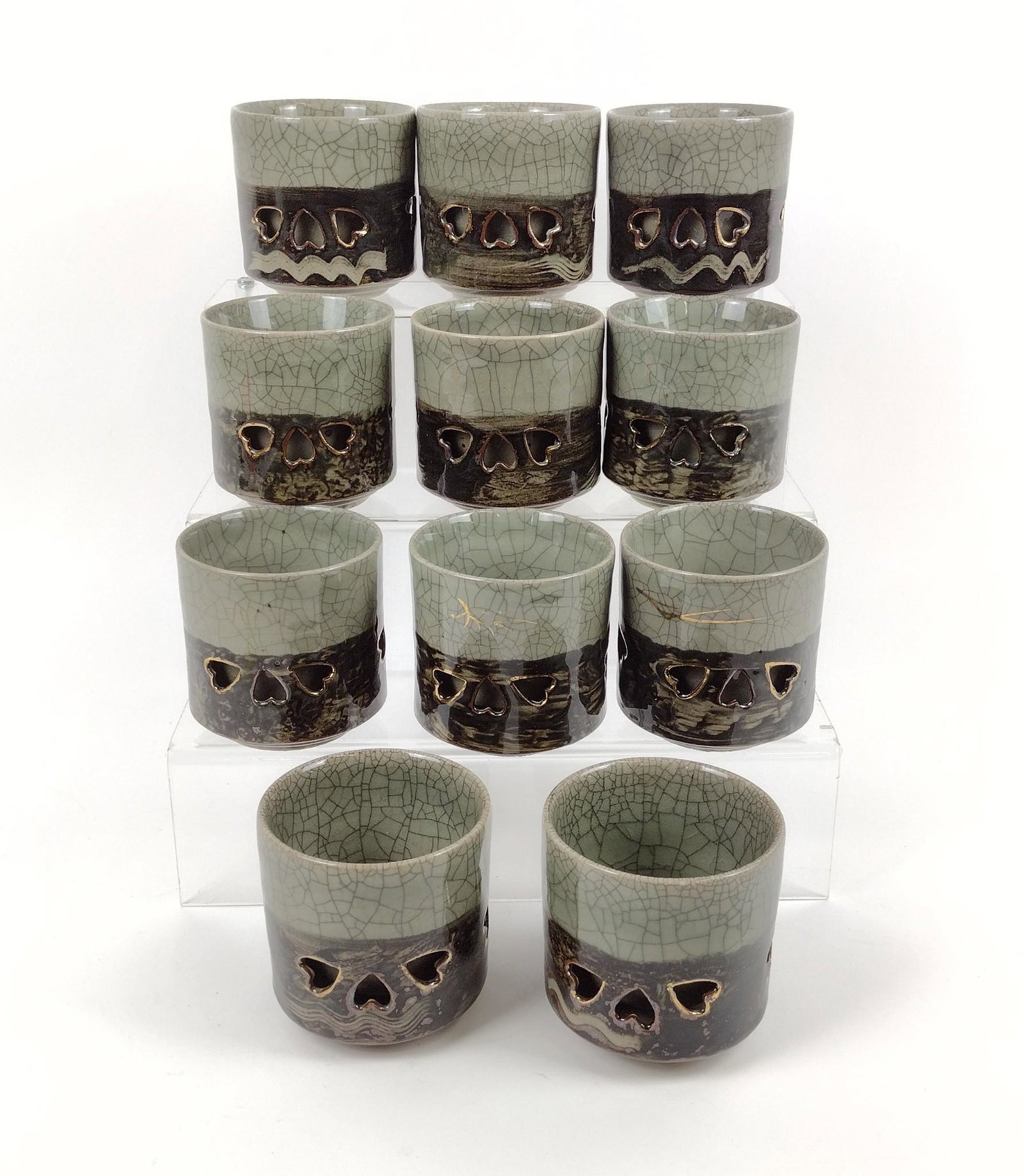 11 Ceramic Cups with Heart Pattern: 3-1/2" diameter X 3-3/4" high. MEG Provenance: From the estate of Mary Trost who last resided in the multi generational family home located in Clarks Valley, Dauphin (Harrisburg) Pennsylvania. Mrs. Tr