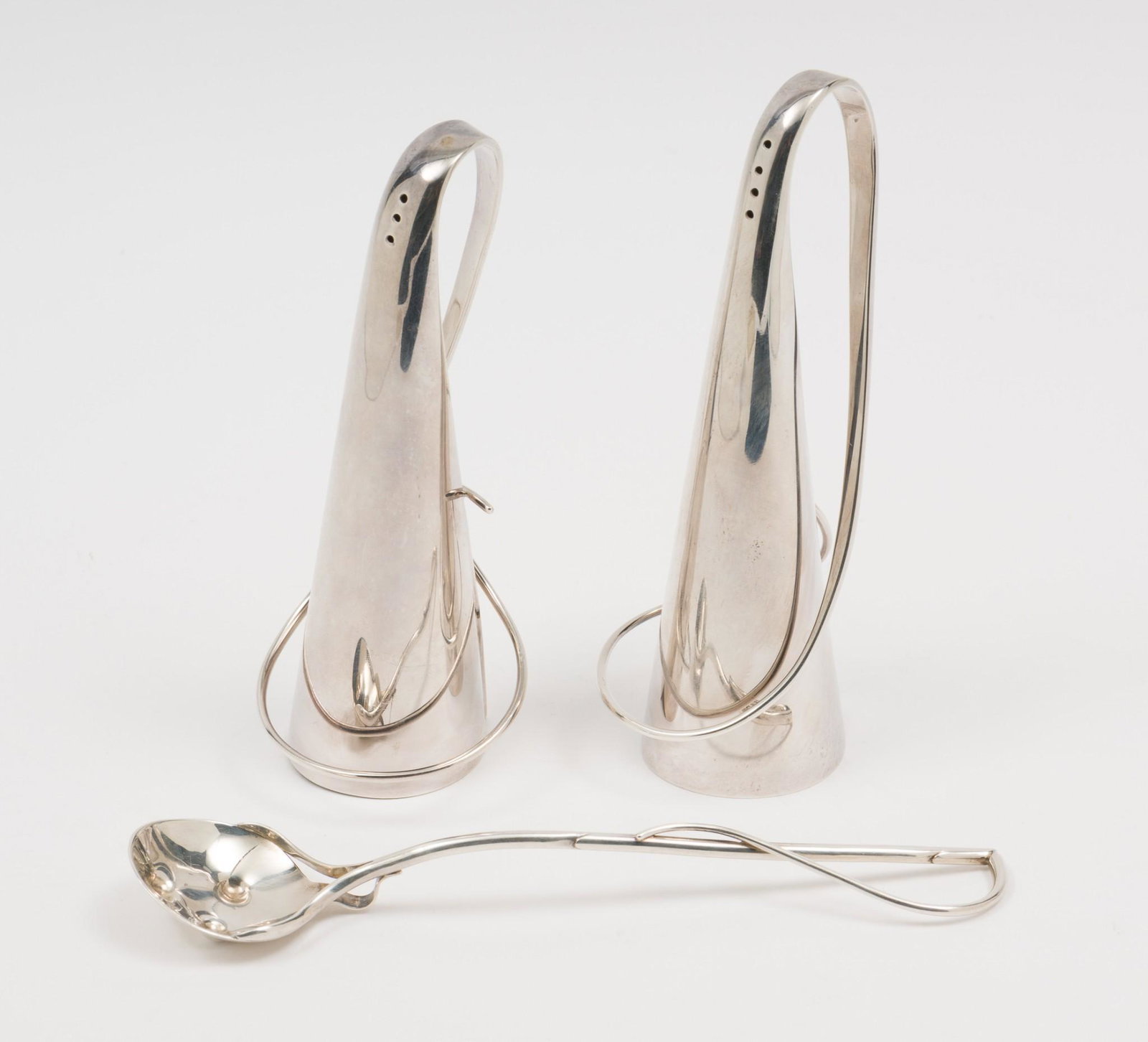 Robyn Nicholas Sterling Shakers & Spoon: Set of two shakers and a spoon by American silversmith Robyn Nichols. All marked sterling. Shakers dated 1990 and spoon dated 1991. Spoon 5-7/8" long and shakers 4-7/8" high. 6.3 ozt. Light wear consi