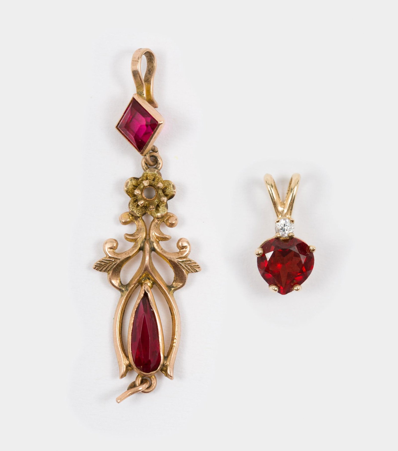 2 10K-14K Gold Pendants: Marked 10k pendant with garnet and CZ. Tested 14k lavaliere with synthetic rubies, missing stone at bottom of drop. 3/8" and 1-1/4" long. 1.2 total dwt. AJ/EK IMPORTANT: Before bidding, please read th