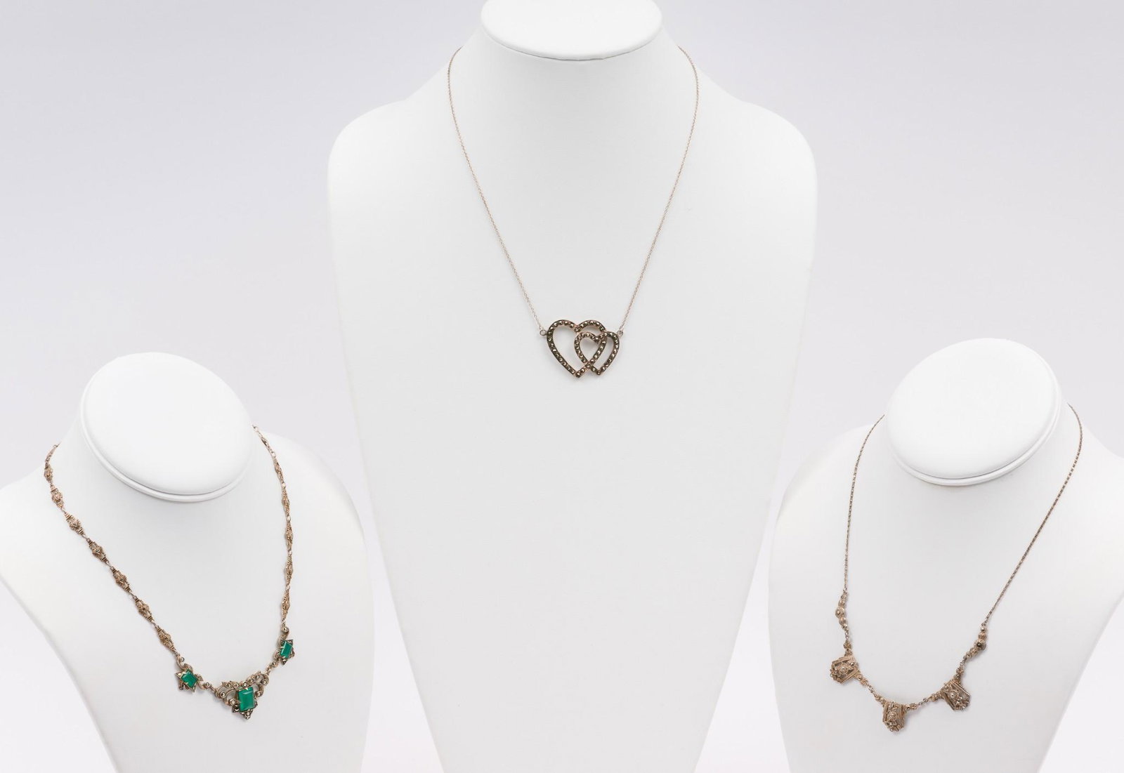 3 Sterling Marcasite Necklaces: Includes floral design and marcasite, deco with 3 green onyx and marcasite, and heart duo with marcasite. Marked 925 / sterling. Chains: 16-3/4" to 19" long. MEG/EK IMPORTANT: Before bidding, please r