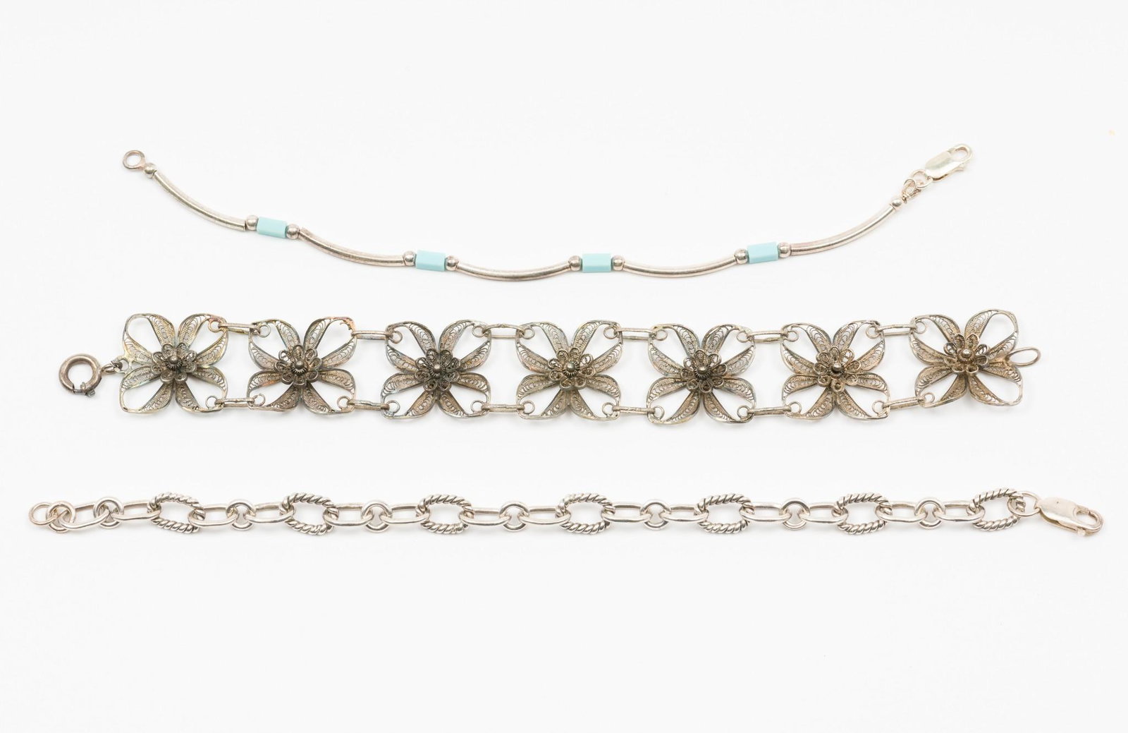 3 Bracelets: Includes floral bracelet, chain link bracelet, and silver and turquoise beaded bracelet. 7-1/2" to 8-1/4" long. Some corrosion due to age. MEG IMPORTANT: Before bidding, please read the terms and cond