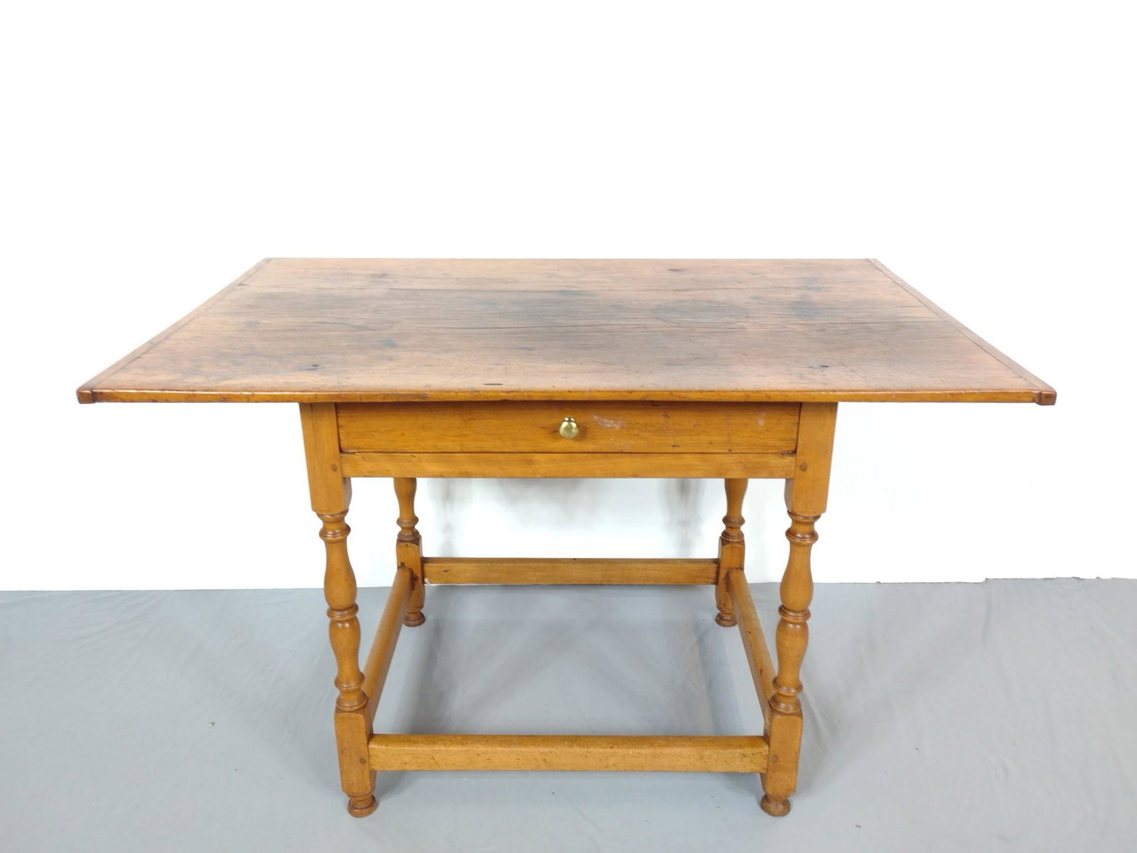 Single Drawer Table with Turned Legs: 43-1/2" wide X 27" deep X 27-3/4" high. Top has some cracks. Also has areas of discoloring. MG. IMPORTANT: Before bidding, please read the terms and conditions. When you registered for the auction you
