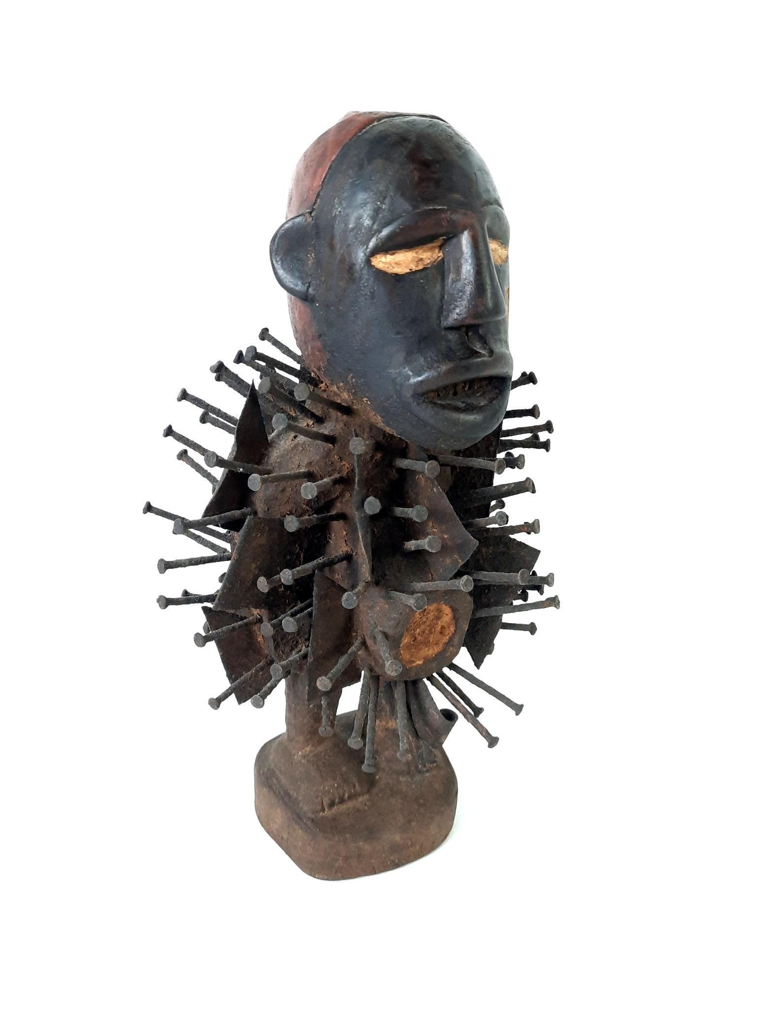 African Nikisi Wood Carving with Iron Nails: 8" wide x 6-1/2" deep x 14" high. LR From the estate of Robert Harman. IMPORTANT: Before bidding, please read the terms and conditions. When you registered for the auction you agreed to these terms an